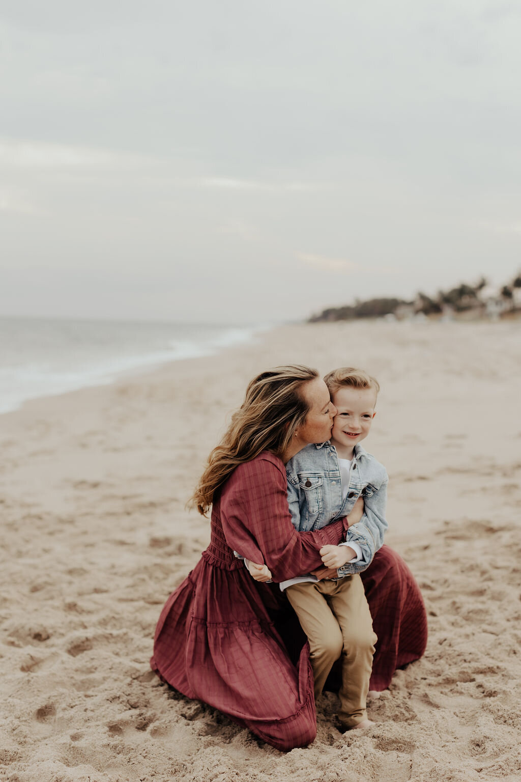 Mom kissing son on beacg