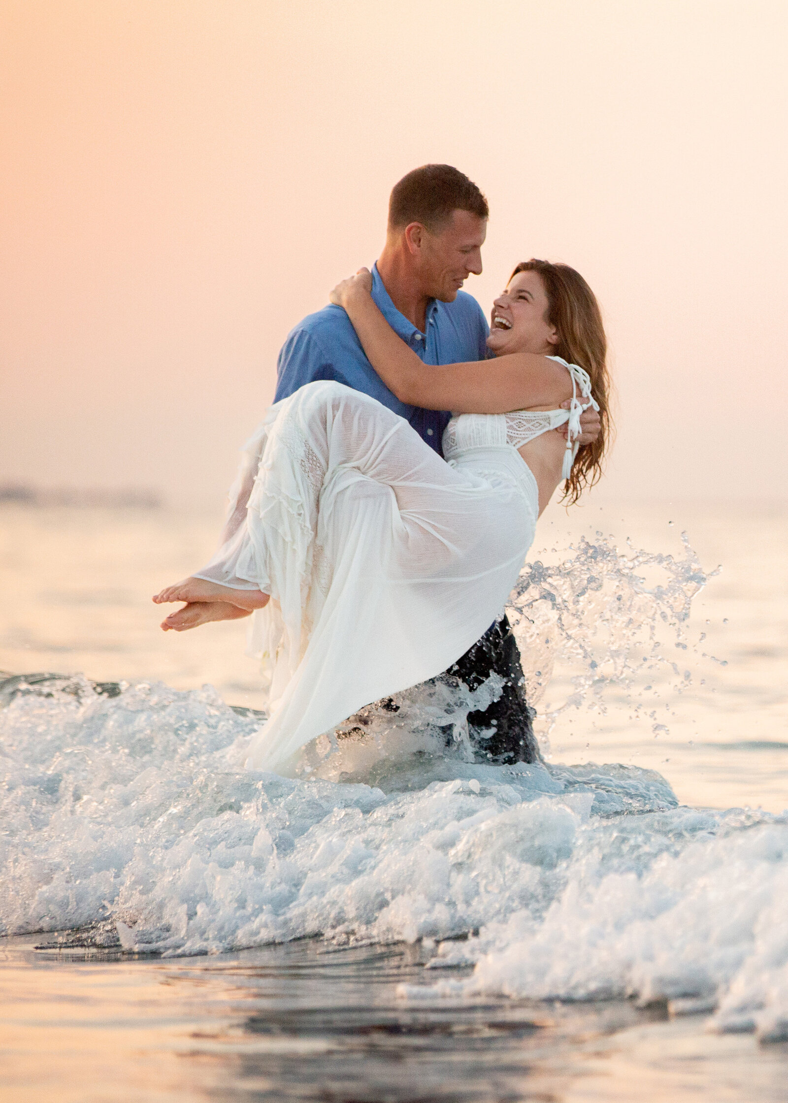 groom-carries-bride-in-ocean-sunset-engagement-lisa-gilbert-photography