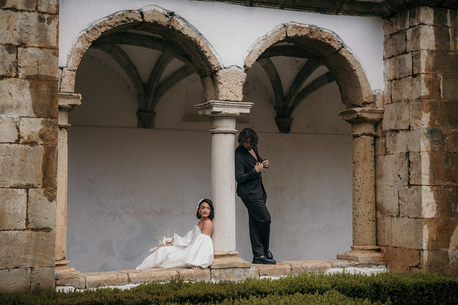 Bride and groom pose in a historical building. 