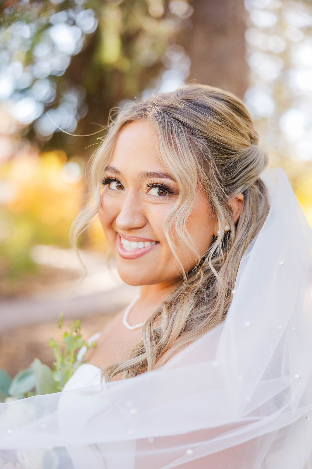 Stunning bride posing on her wedding day in her wedding dress with her veil in her hair and bouquet in her hands. This wedding was at the Botanical Gardens in Cheyenne, Wyoming.