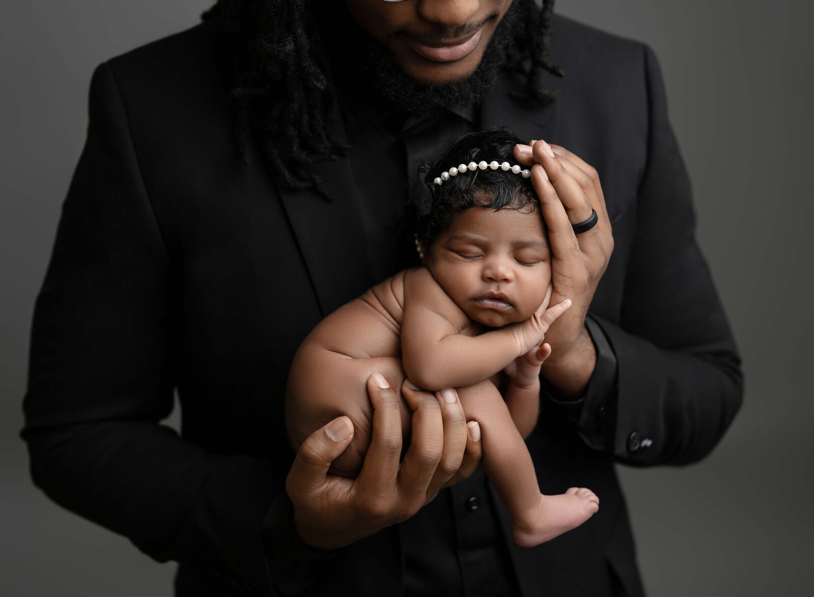 Baby naked and sleeping in dad's hands. Photographed by Jenni Nikki Photography at Marietta Newborn Photo Studio.