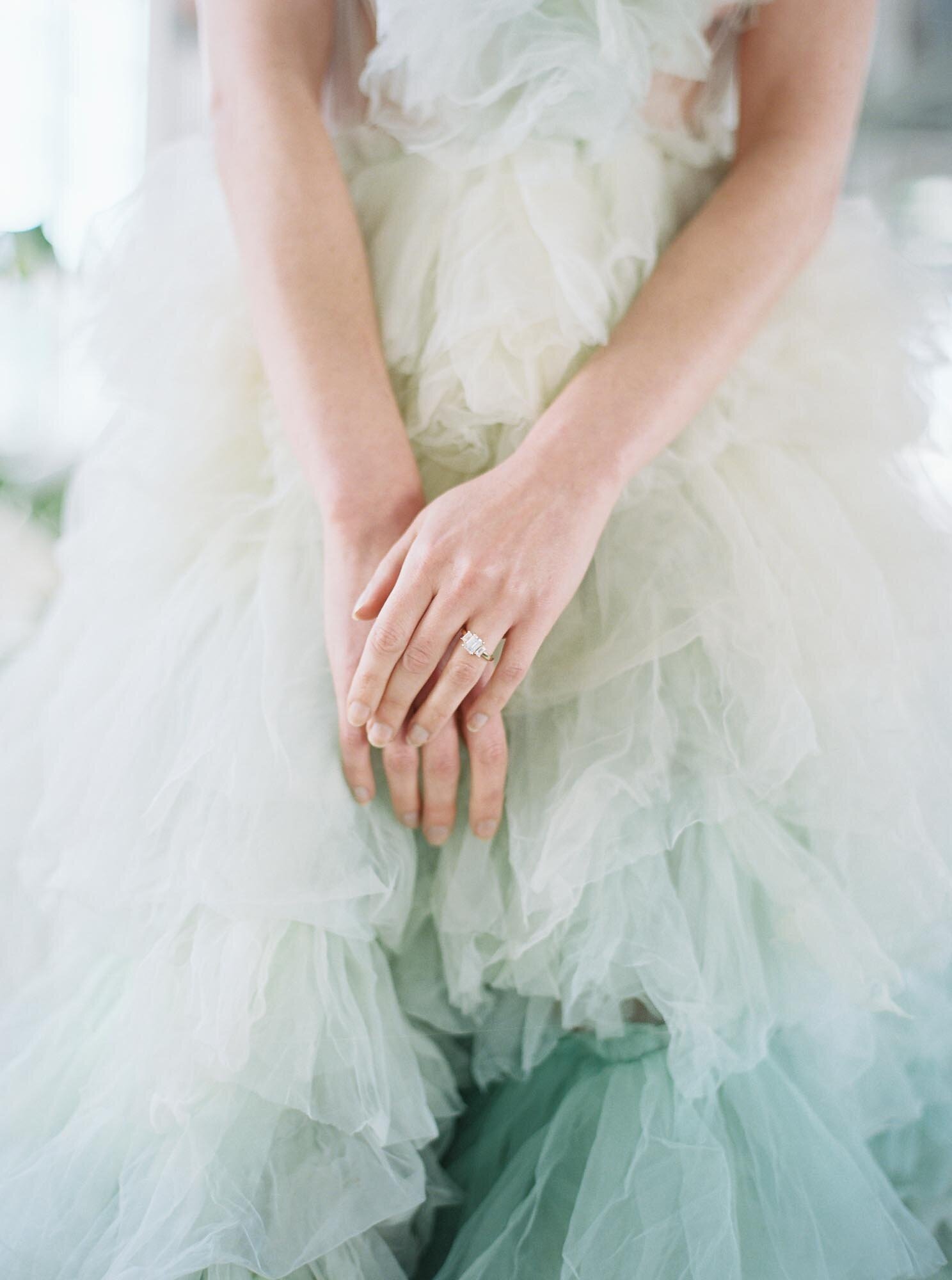 Bride's hands closeup with a Millia London green dress