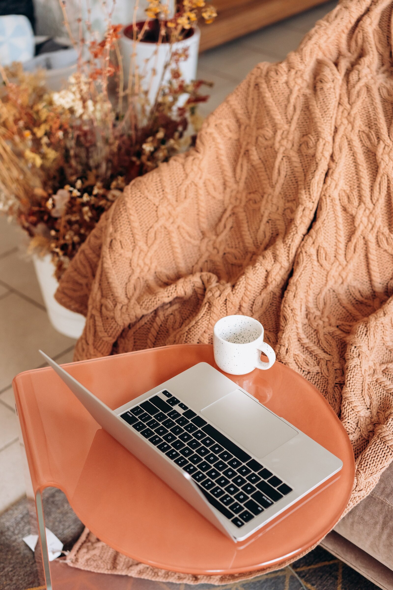 orange computer, blanket and table