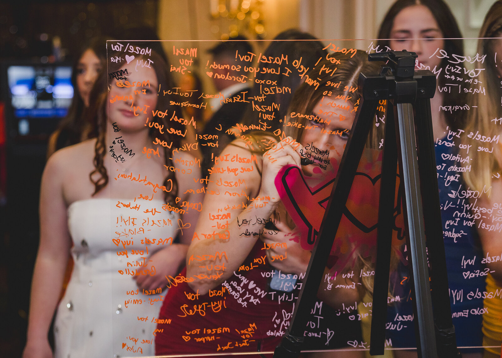 Guests write congratulatory messages on a clear "guestbook" sign.