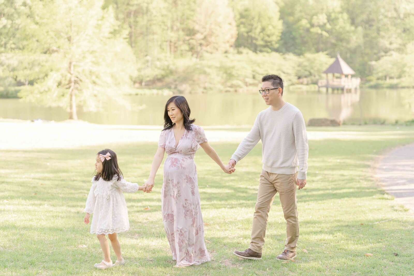 big sister lead parents to the field during Loudoun County, Virginia maternity session