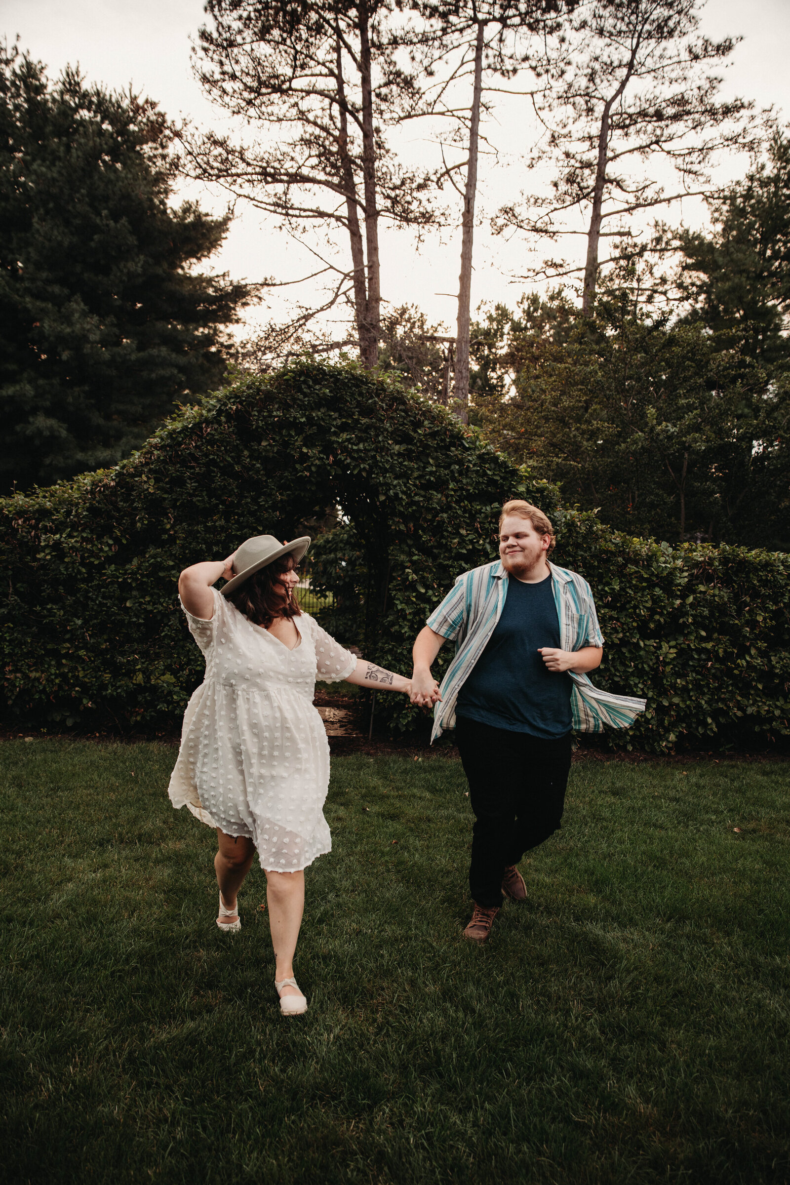 Couple runs toward a unique engagem photographer in Schopfle Garden