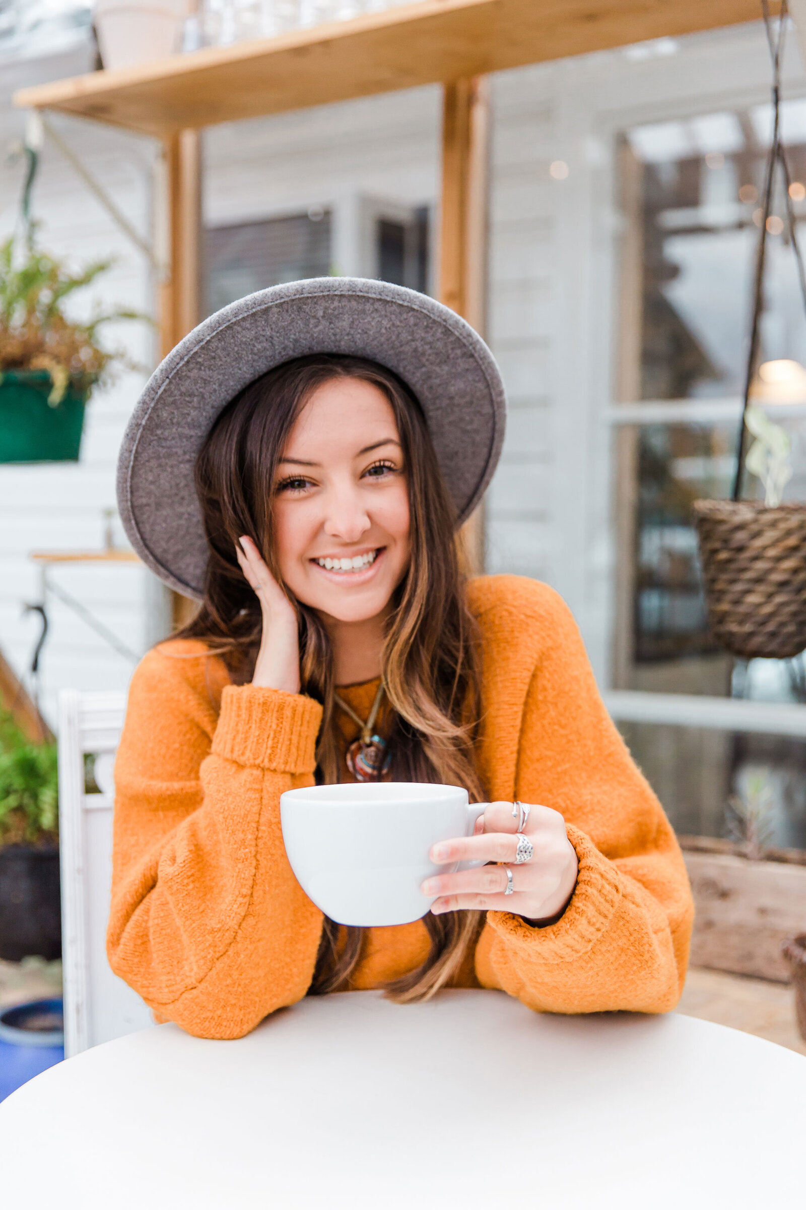 senior girl posing for fall portraits holding a coffee cup