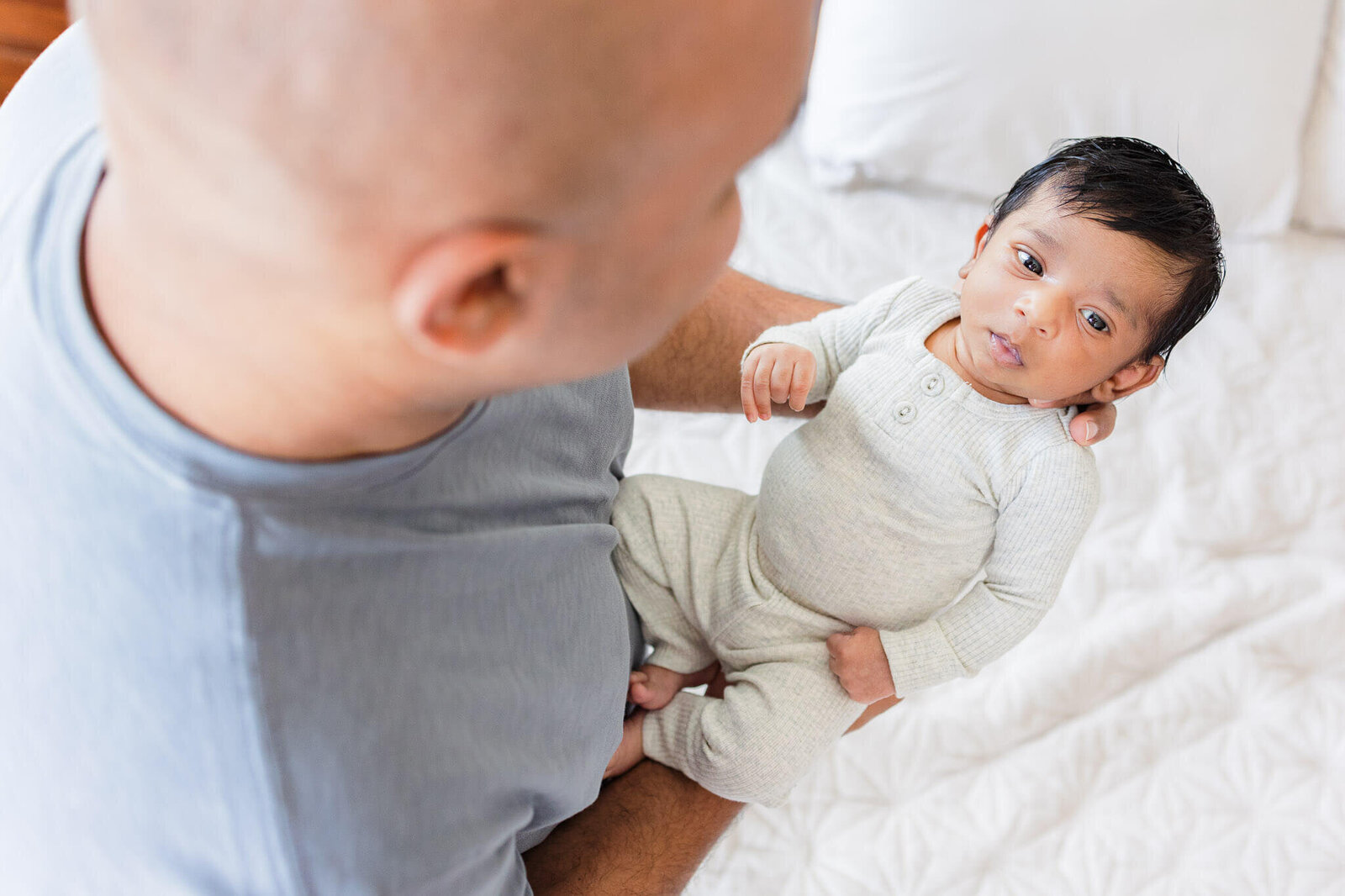 A dad holding his newborn son.