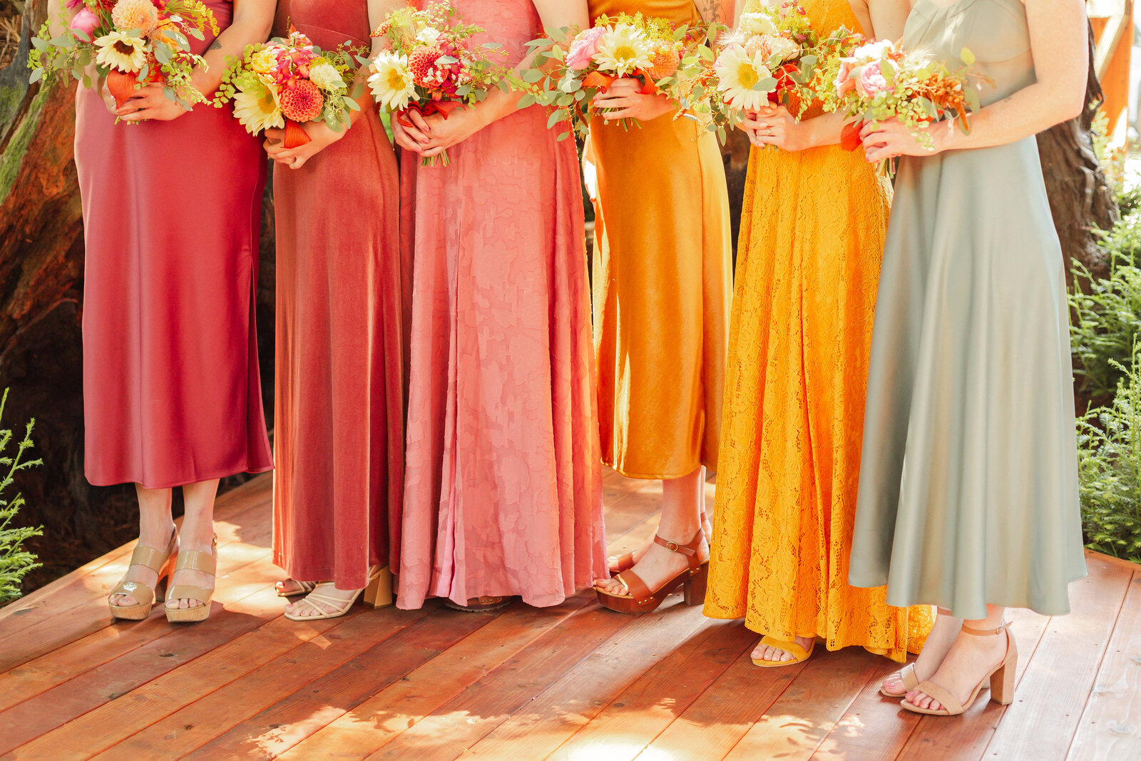 Bride and bridesmaid at her colorful wedding ceremony in Santa Cruz, California in the redwood trees.