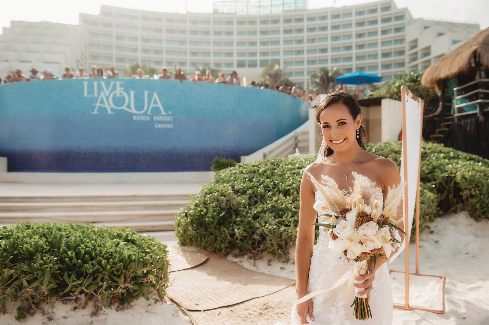 Bride glances into the camera as she walks down the isle at Live Aqua Resort in Cancun Mexico.
