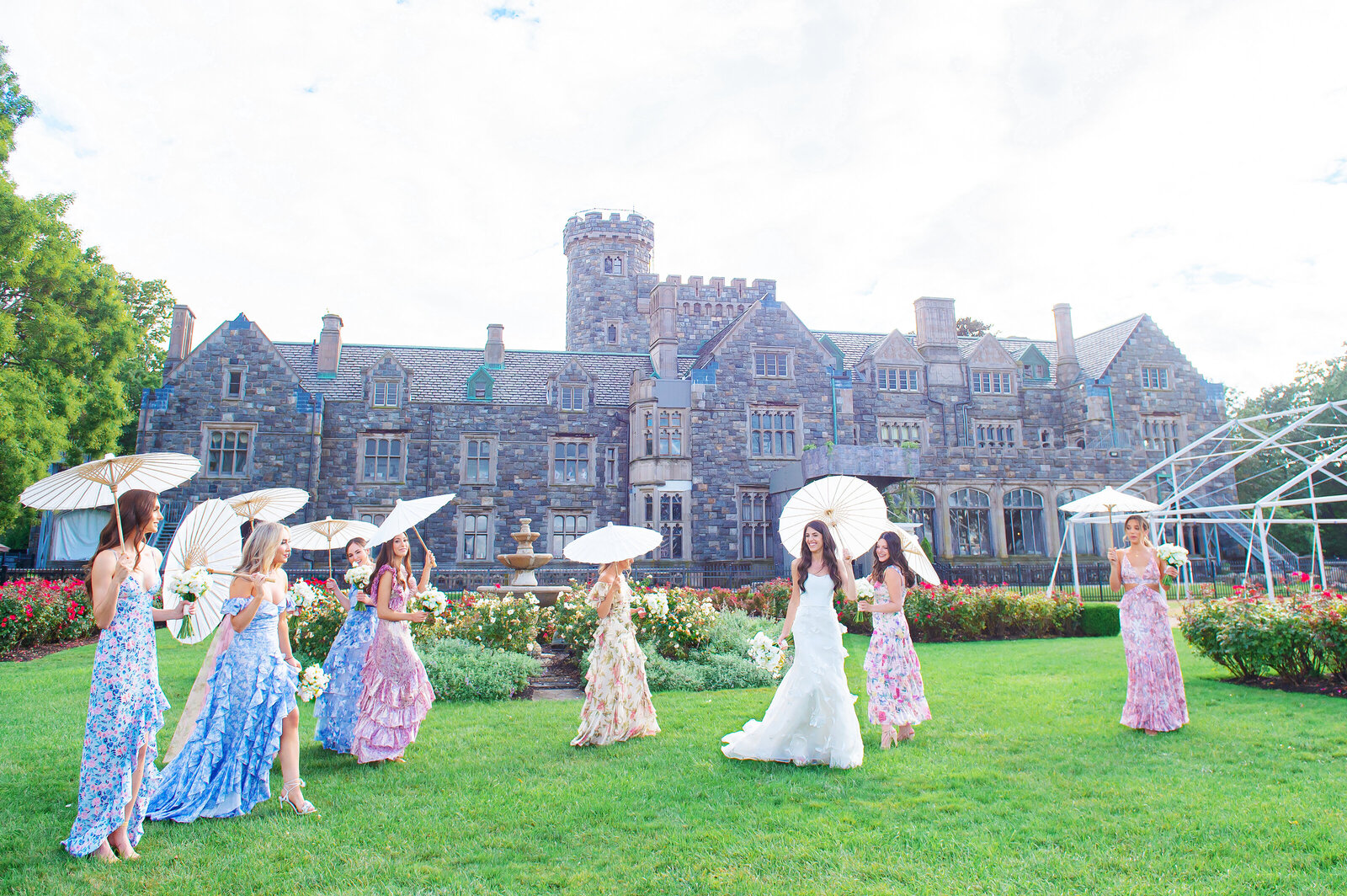 Bride and bridesmaids walking outside with parasols