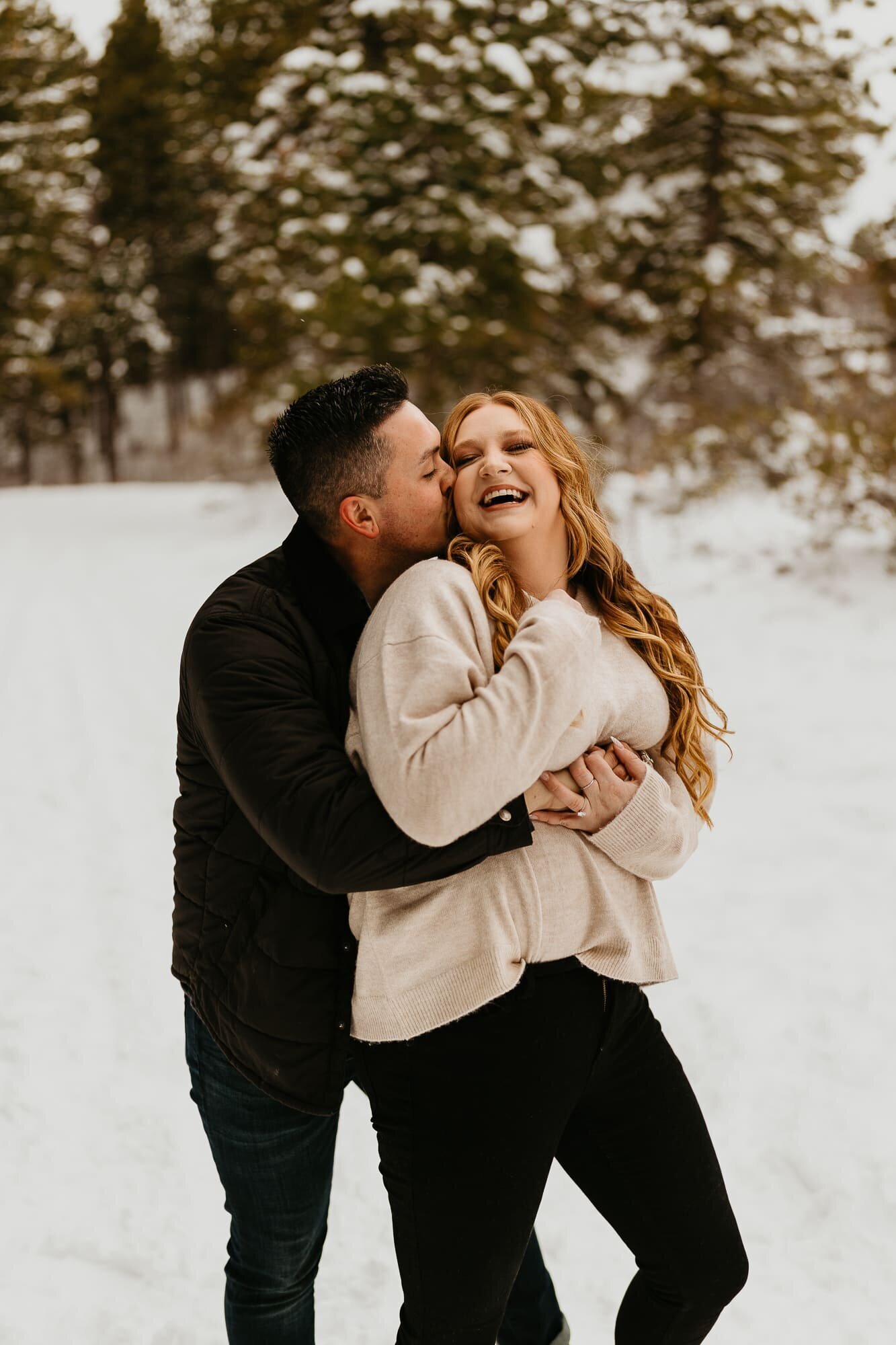 A couple embracing during their engagement photo session at Bogus Basin above Boise, Idaho