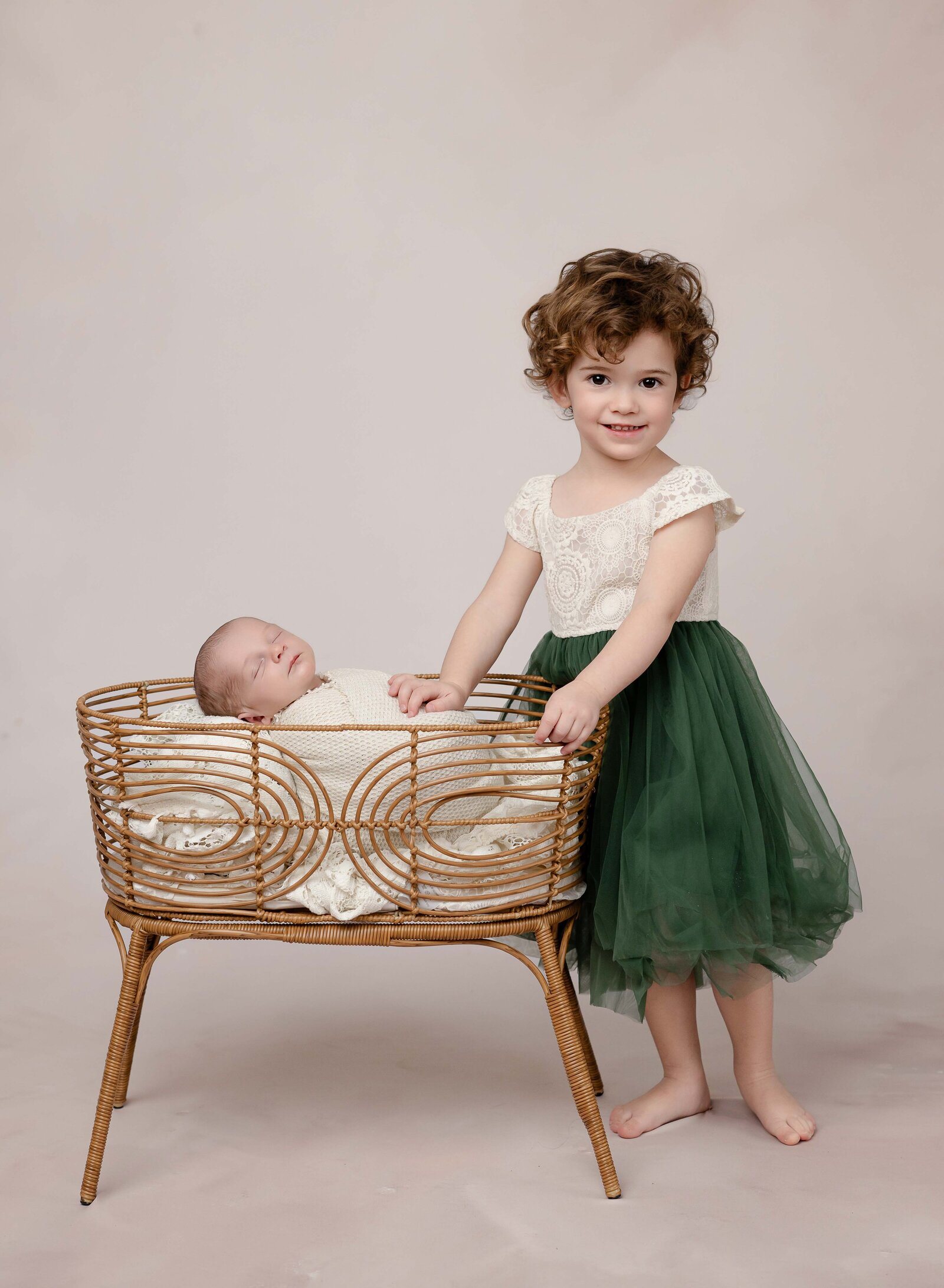 Sleeping baby in bassinet with sibling touching them. Photo by Jenni Nikki Photography, Marietta Newborn photographer.