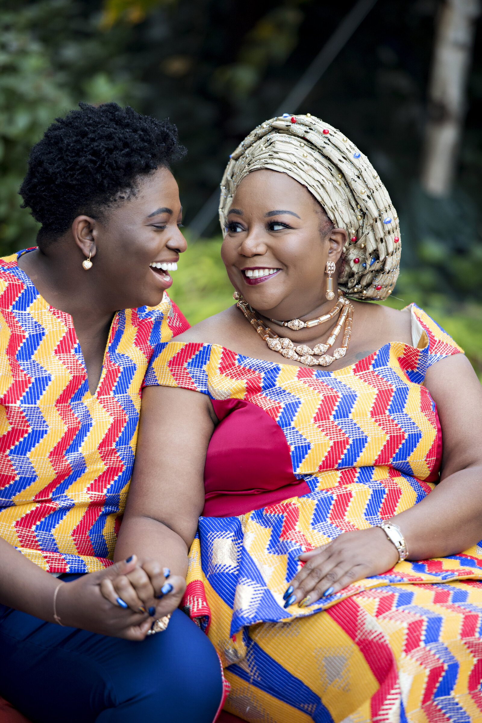 A couple sitting together holding hands and smiling at each other 