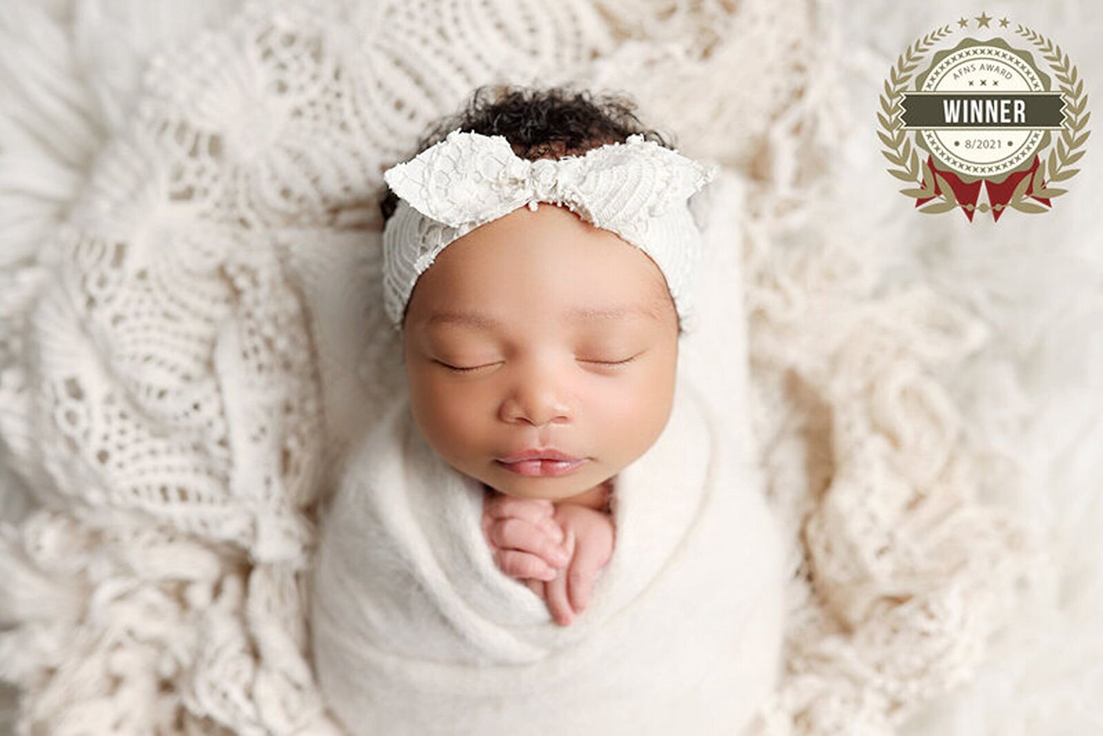 Newborn wrapped in a white cozy blanket