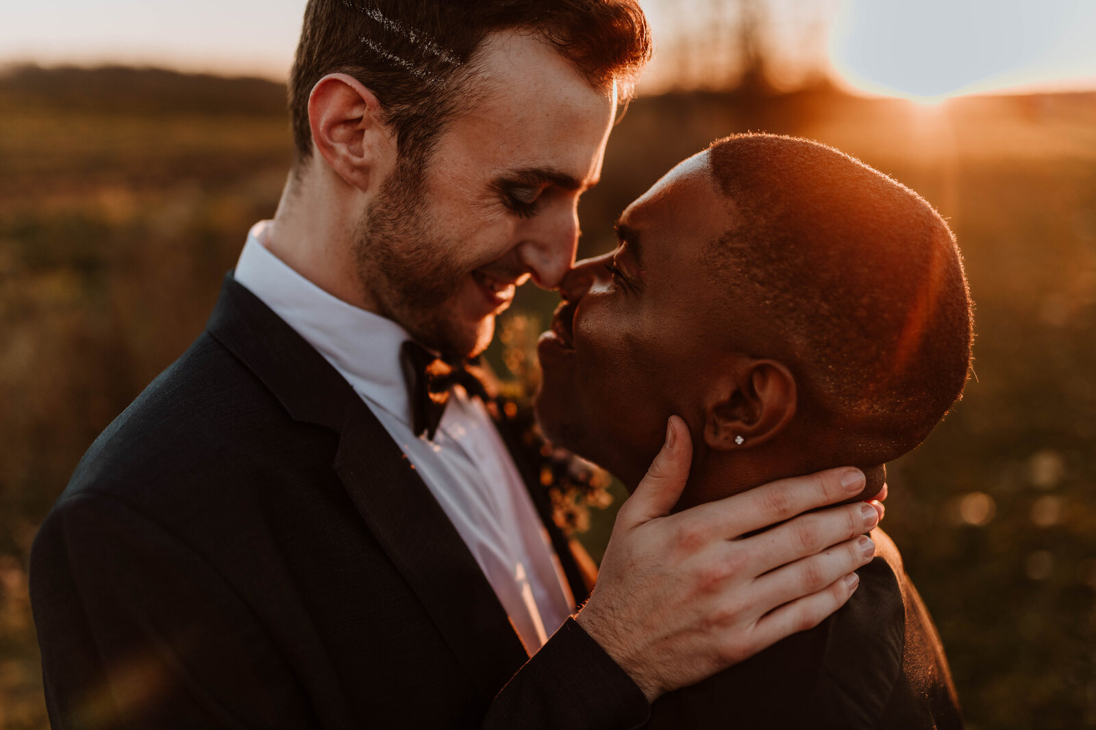 Eloping couple kissing during sunset.