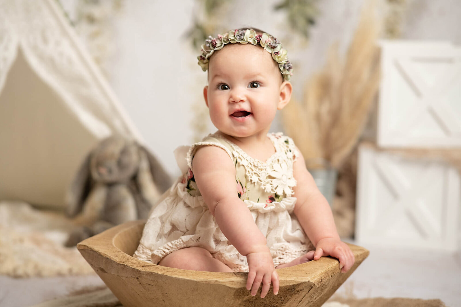 7 month old girl smiling in wooden bowl