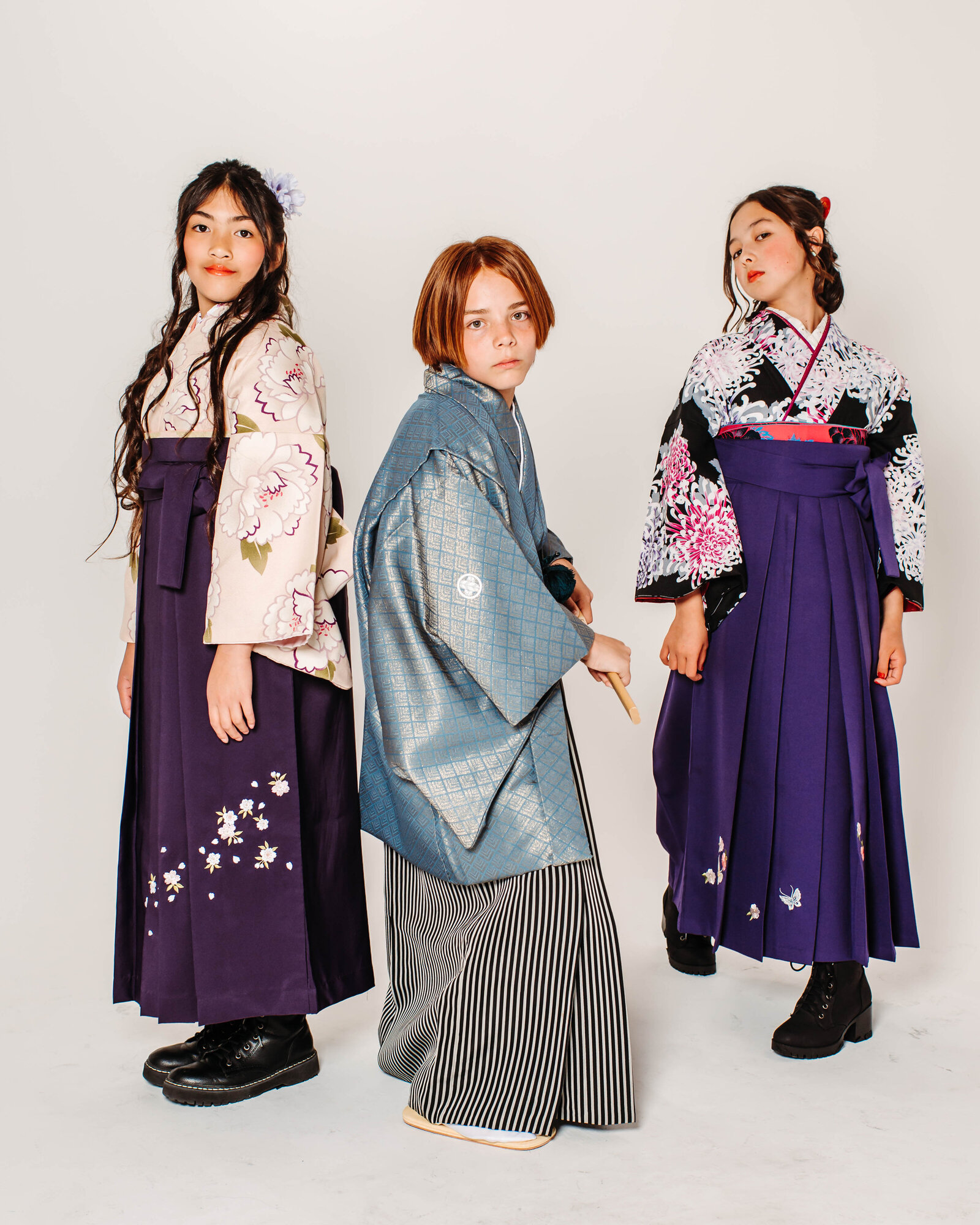 Three students in graduation hakama posing together, two girls in colorful hakama and one boy in blue montsuki | 卒業式 袴 三人 和装 記念写真