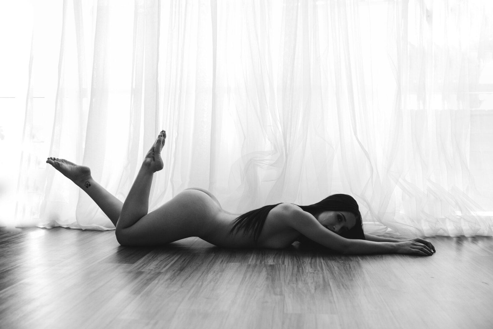 Artistic black-and-white boudoir photography that captures raw emotion, confidence, and strength. A timeless beauty portrait taken in our high-end boudoir studio