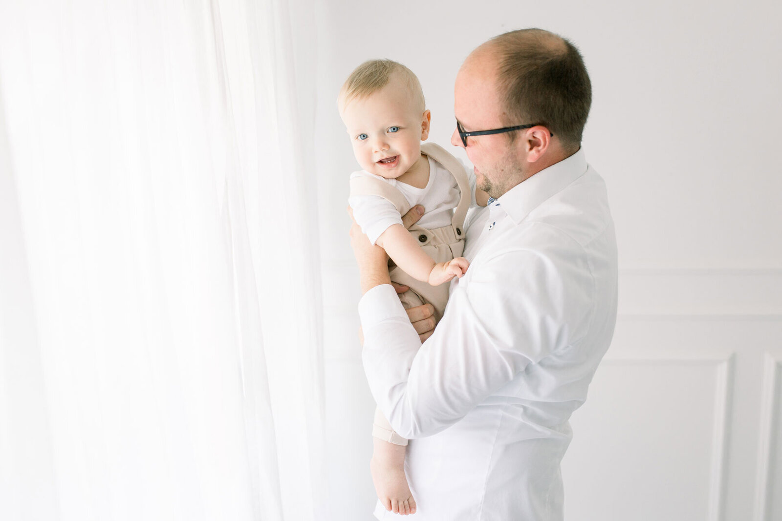 Babyfotoshooting von Babyfotografin bei Bielefeld von Vater mit kleinem Sohn auf dem Arm.