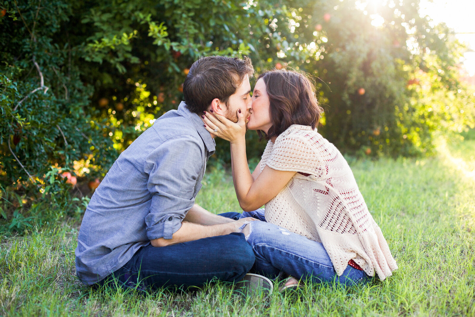 engagement photo of couple sitting and kissing