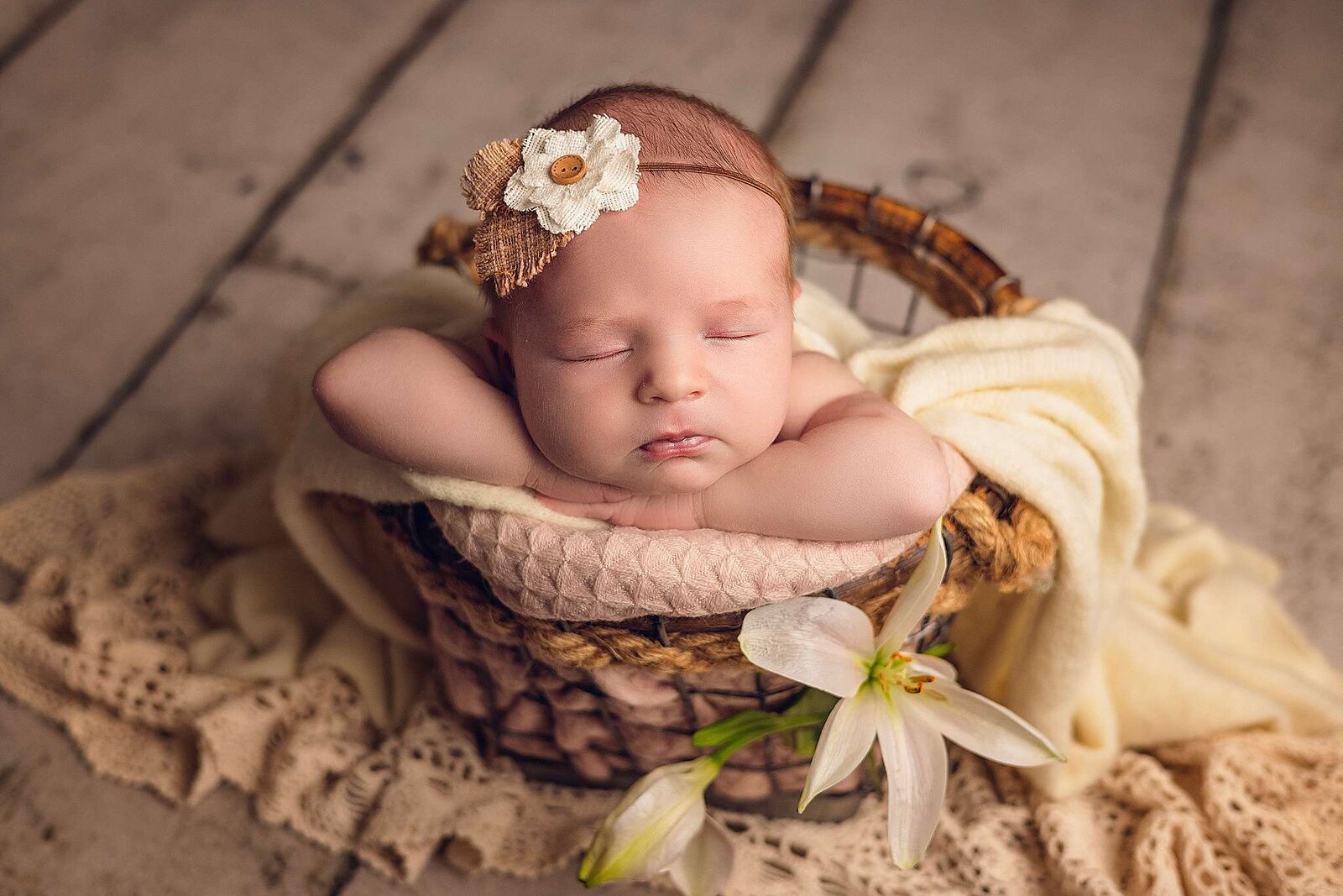 Adorable newborn baby girl sleeping soundly in a basket, captured by Bia Schaefer, specializing in Orlando newborn photography.