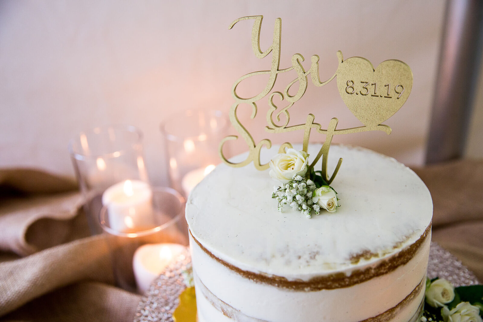 Naked wedding cake with flowers and couple name.