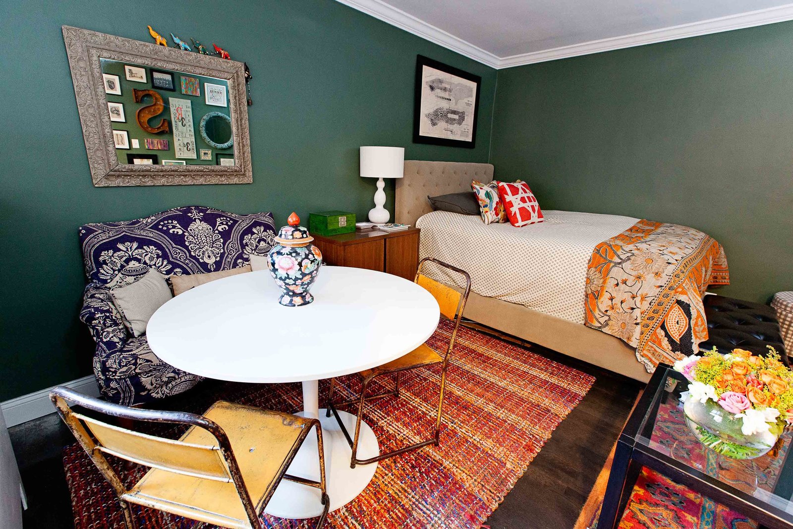 A dining area next to a bed in a studio apartment.