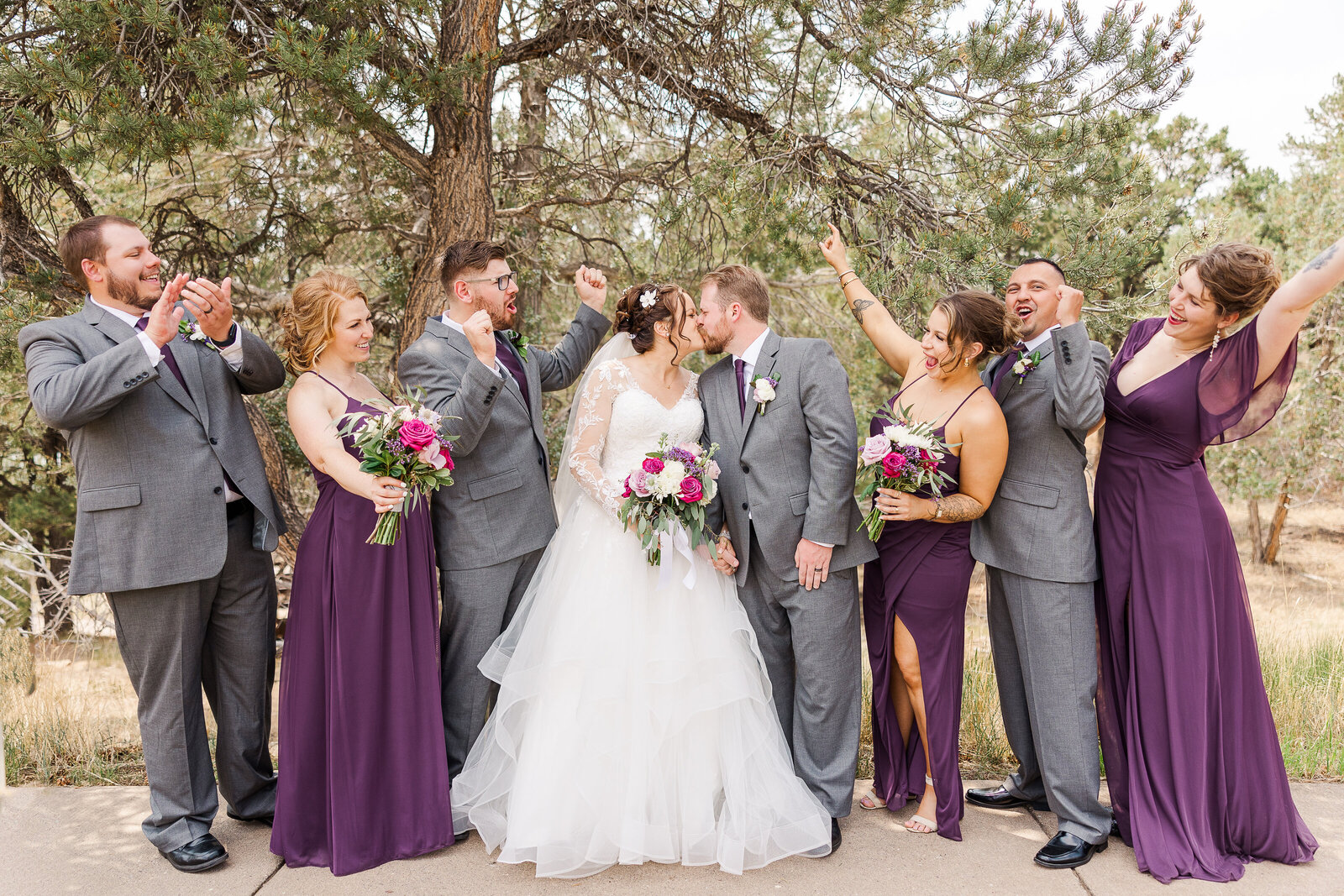 The entire wedding party cheering and celebrating together at a Ridgway State Park wedding, surrounded by stunning mountain views