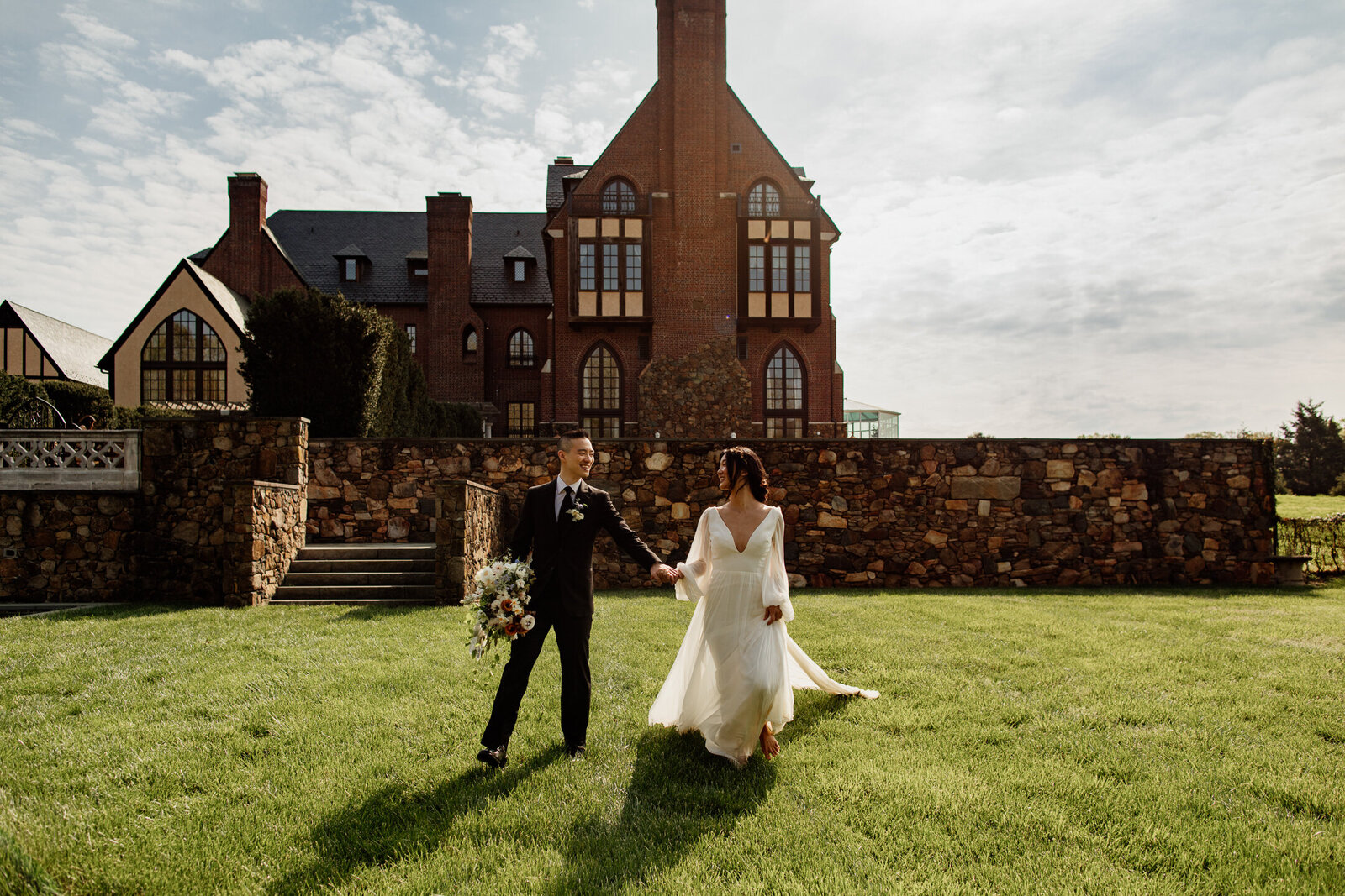 Wedding couple walking on lawn in front of wedding venue