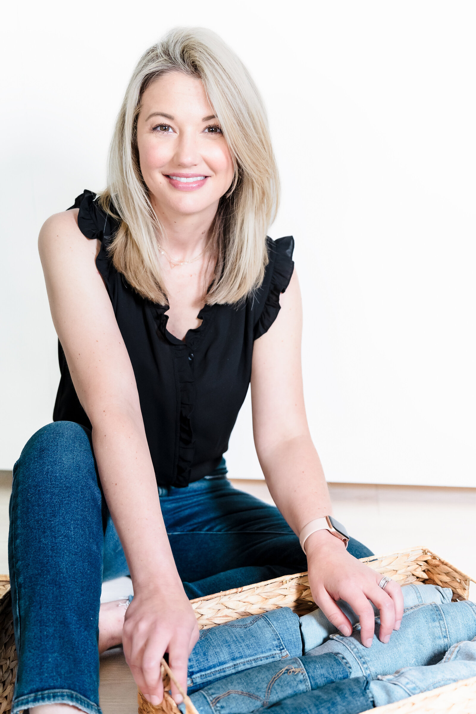 brand photo of a professional organizer sitting with a box of jeans pants