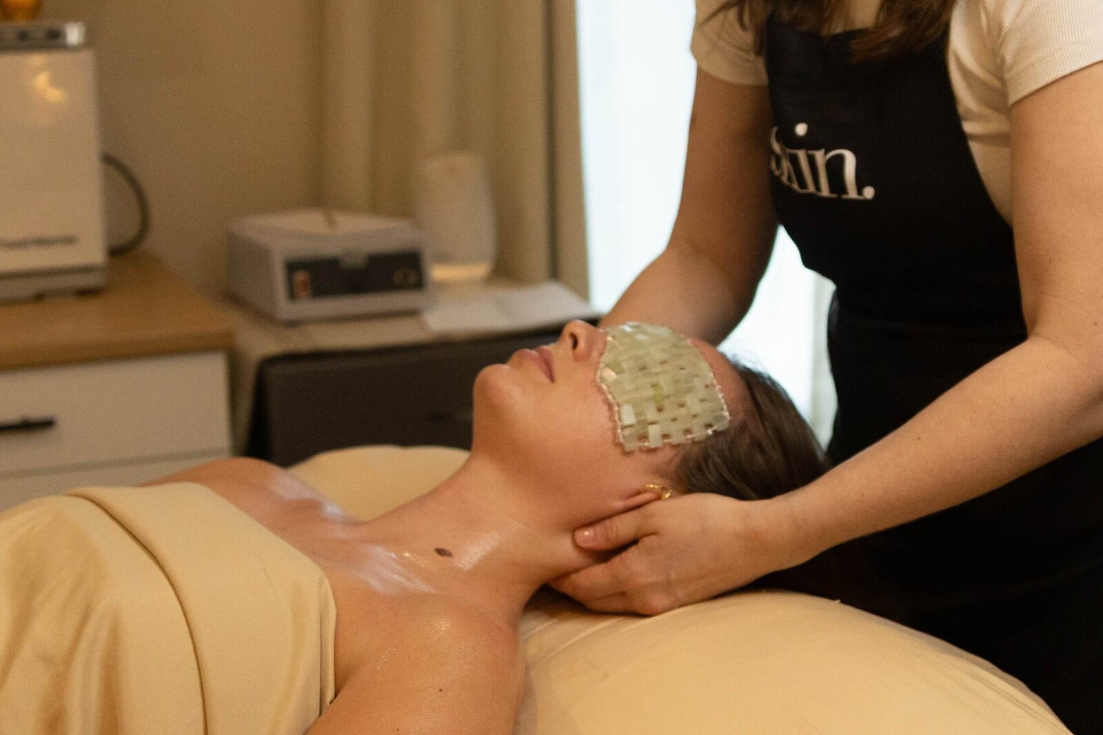 Client resting during a targeted facial treatment in a softly lit spa room.