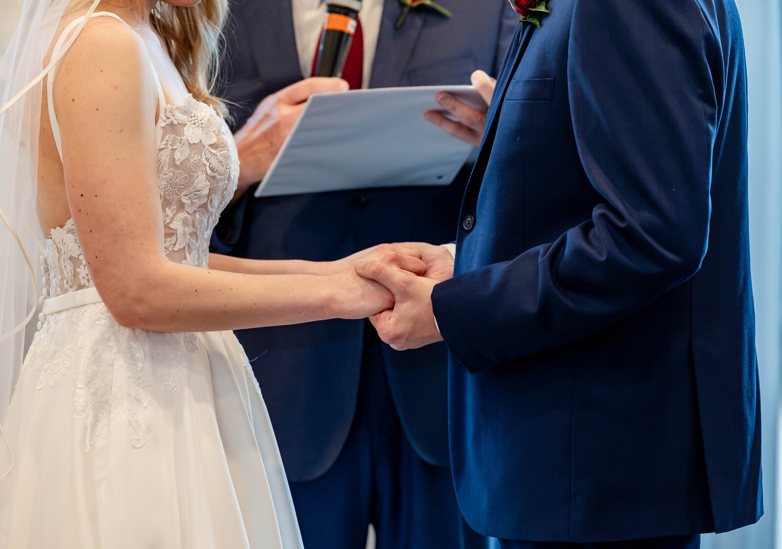 Bride and groom holding hands while saying their vows at Piazza Messina in Cottleville, MO, beautifully captured by Style & Grace Photography.