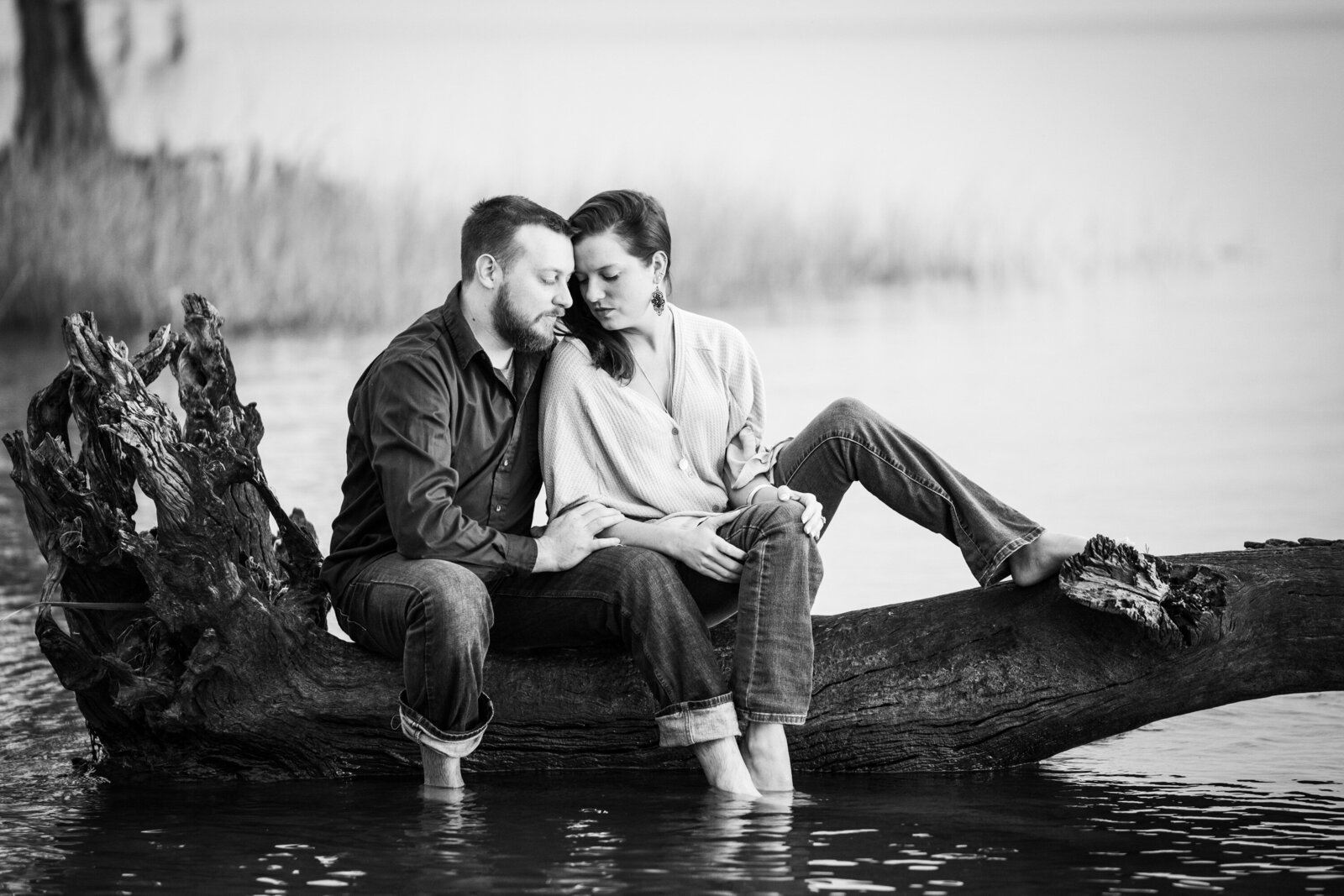 Couple sitting on downed tree in the water at Fontainebleau State Park