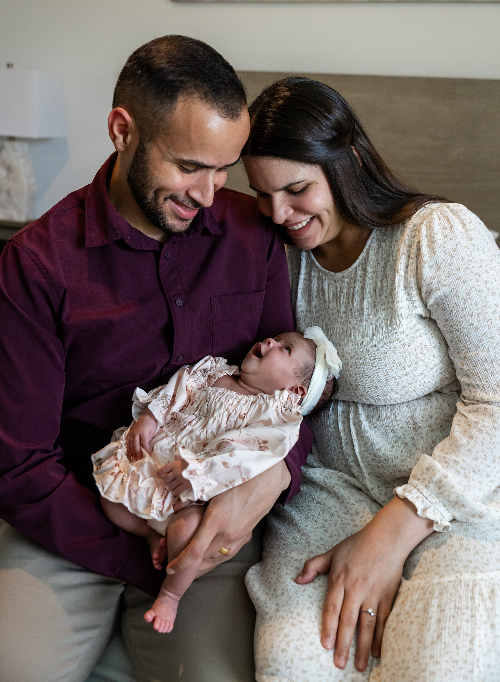 mom and dad smiling at newborn girl