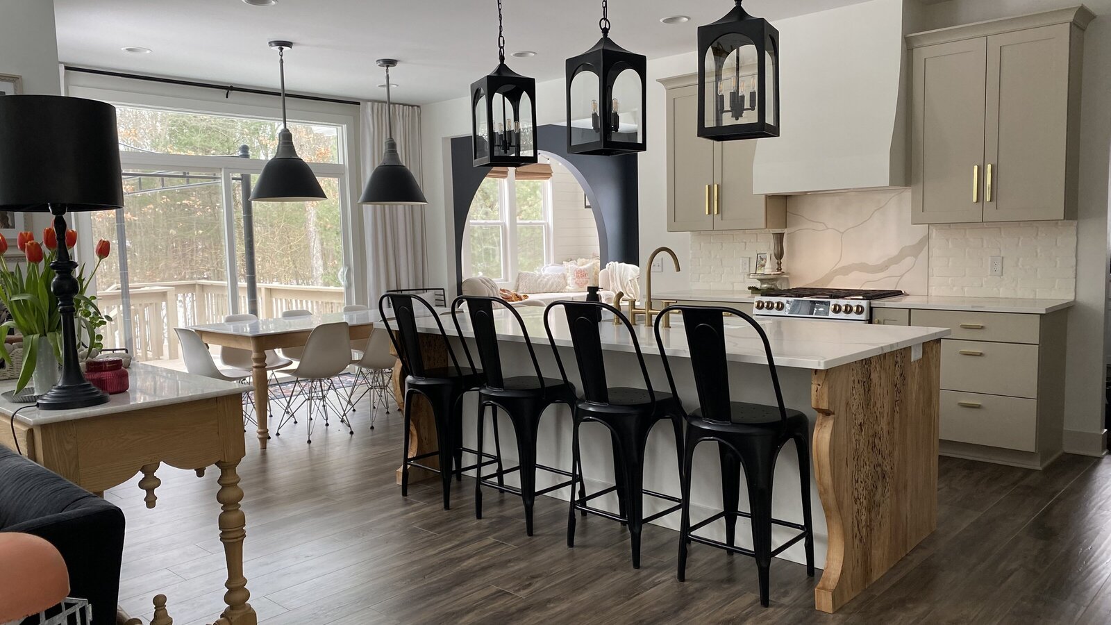 view of a kitchen with black barstools by the island
