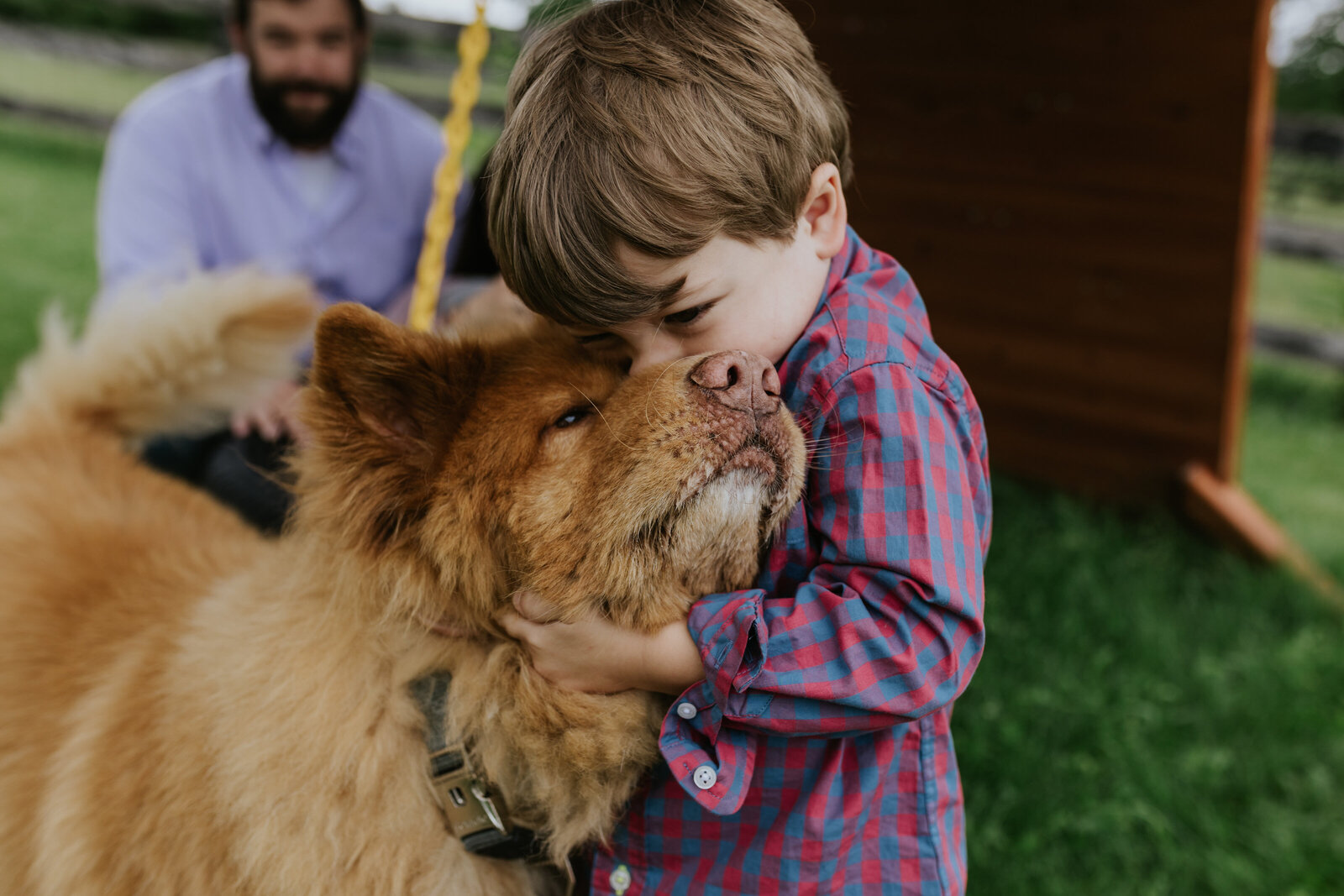 A young boy gives his dog a kiss