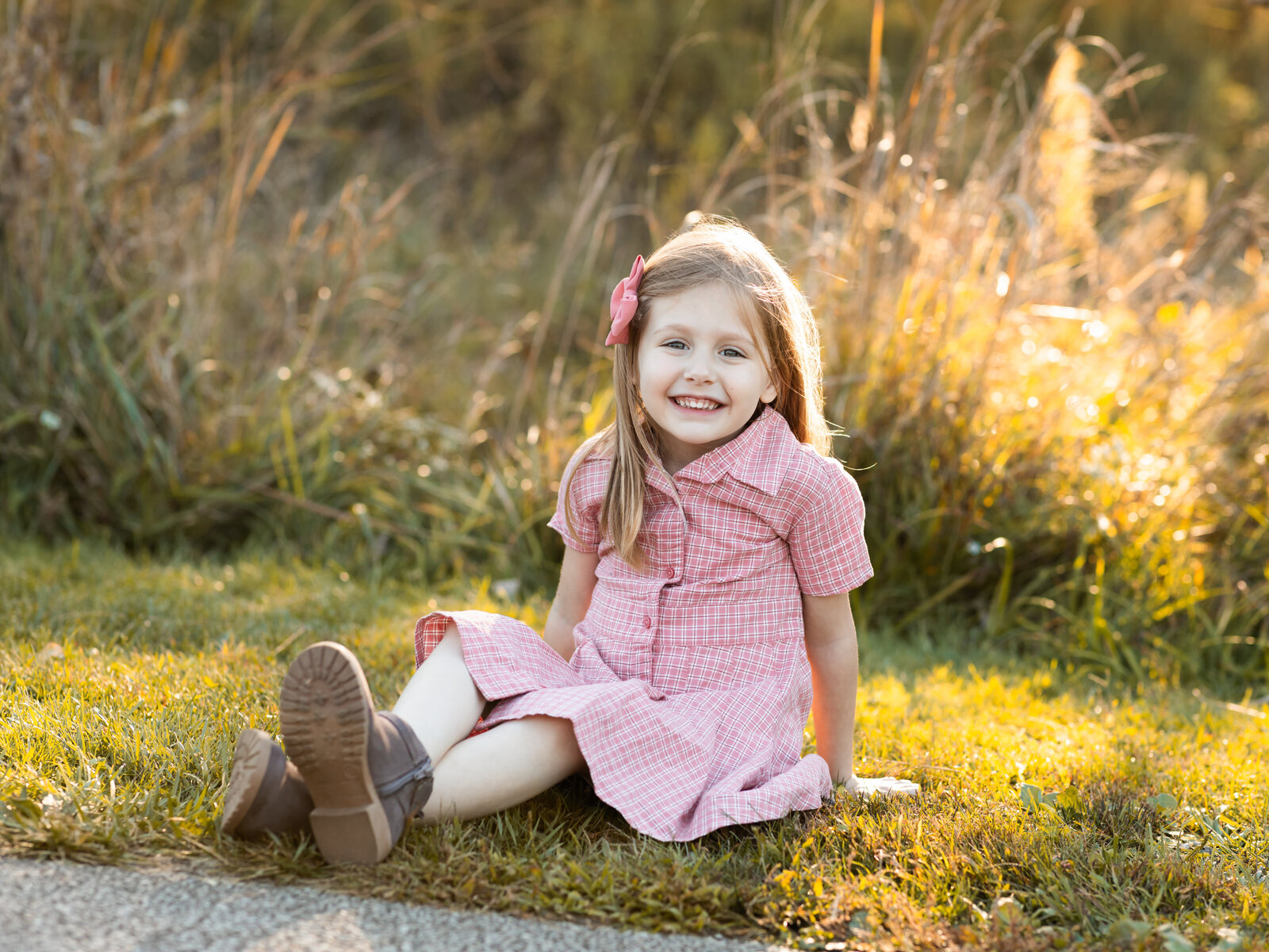 little girl sitting on grass posing for family photos