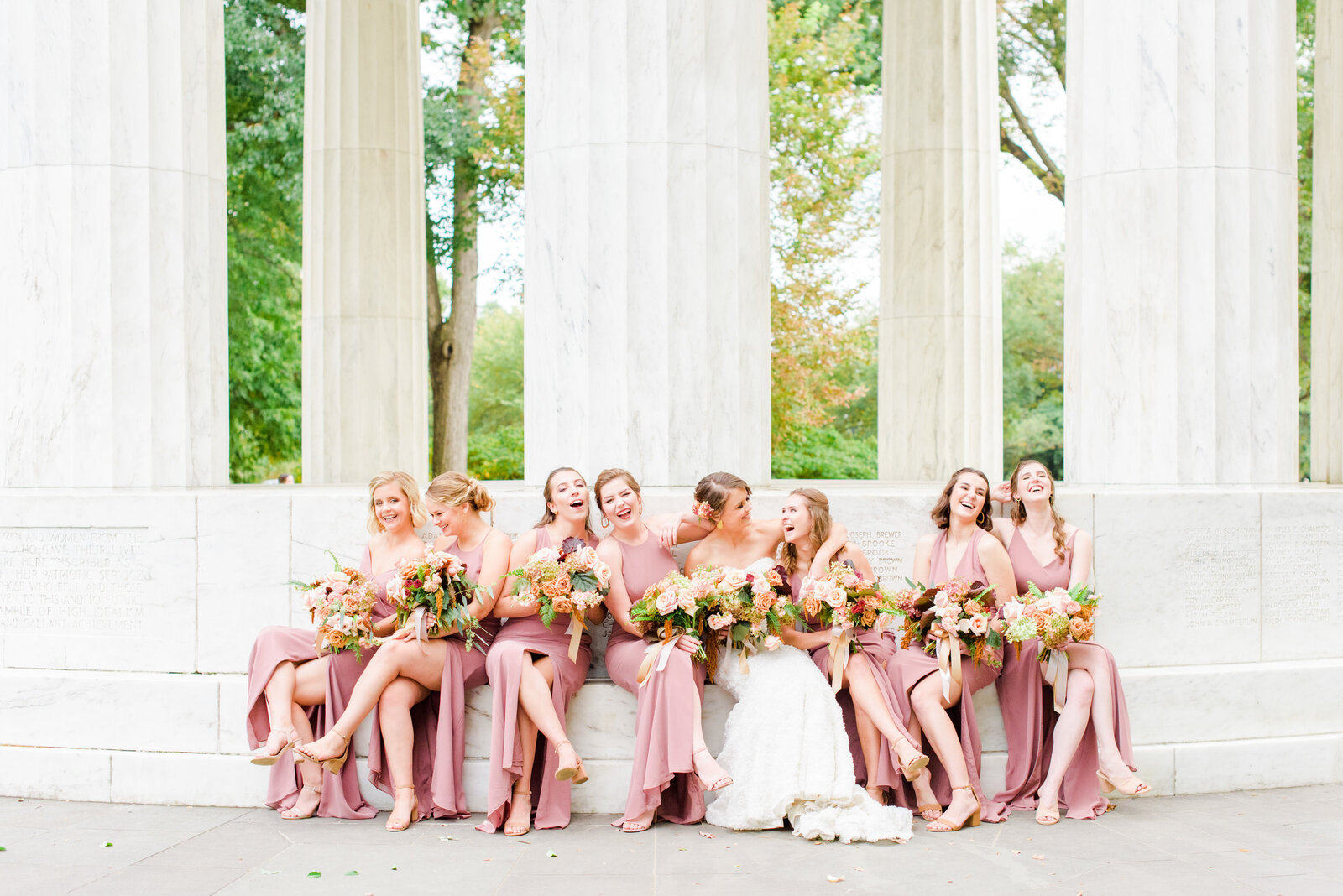 Bridesmaids celebrate with the bride at the DC War Memorial after her outdoor ceremony on the national mall