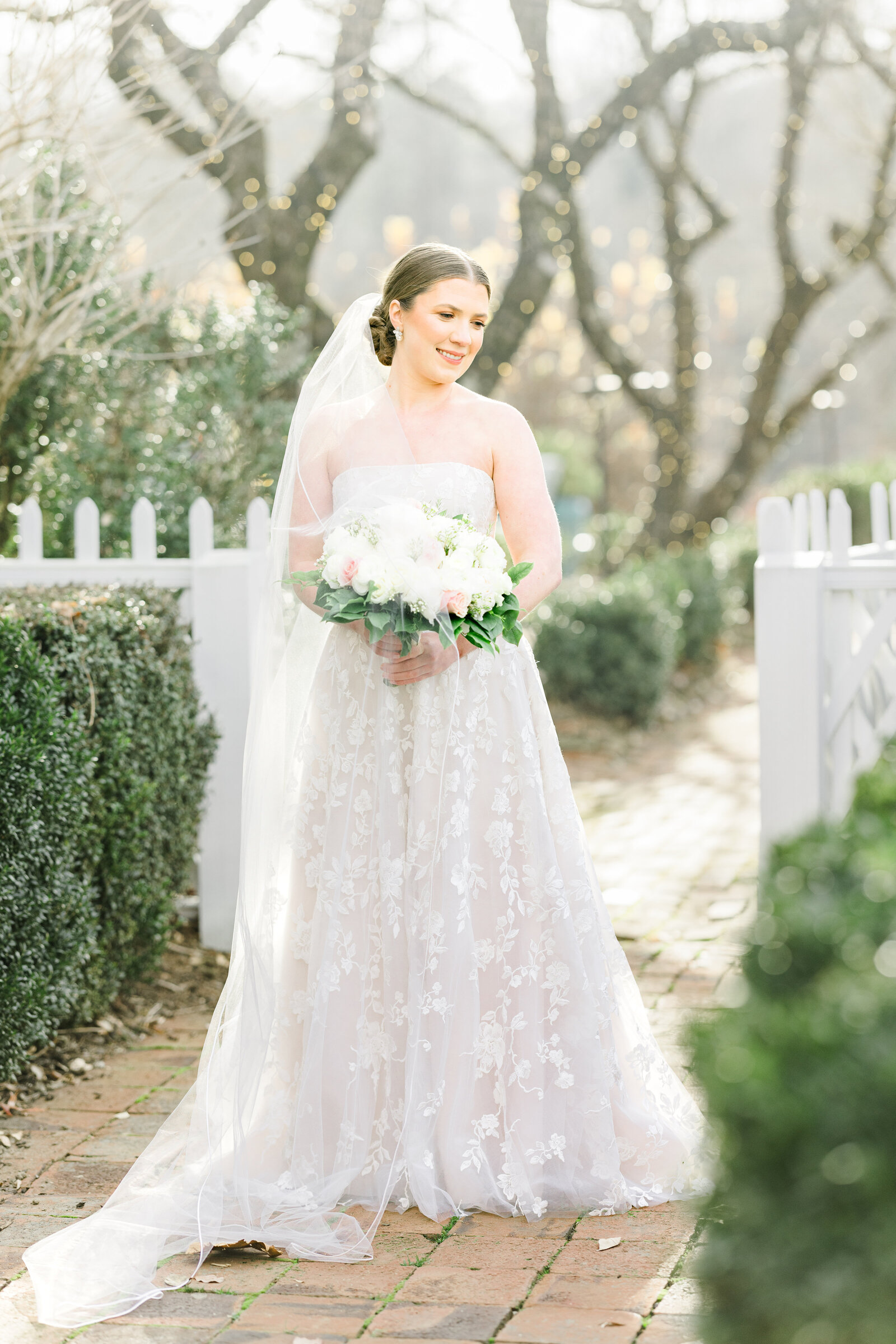 Bride poses gracefully at Inola, her wedding gown flowing as she smiles, radiating joy and anticipation for the unforgettable day ahead.