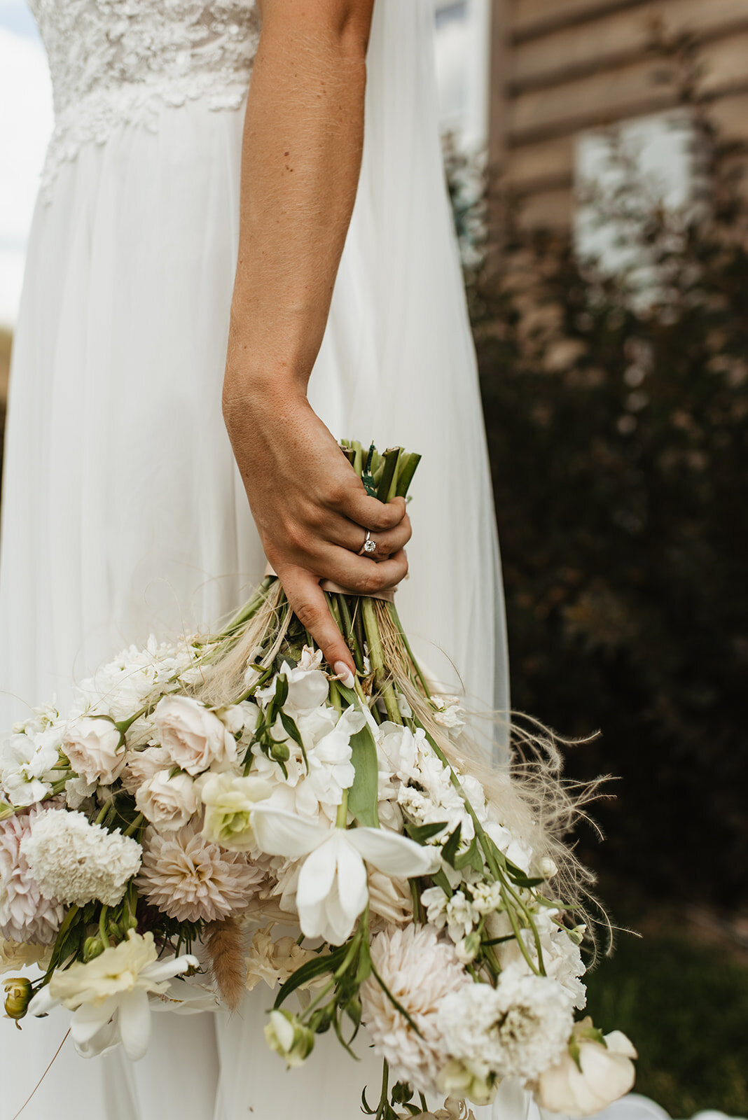 Bride holding her white floral bouquet upside down