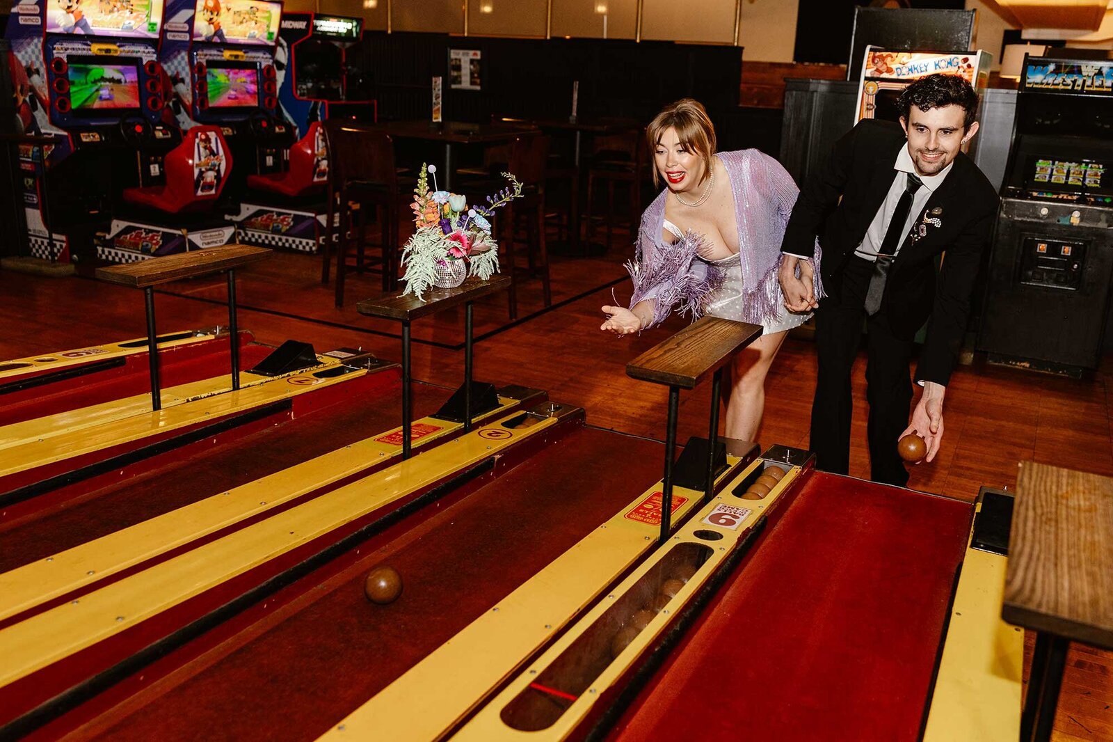 A couple plays skee ball during their elopement in Lancaster city