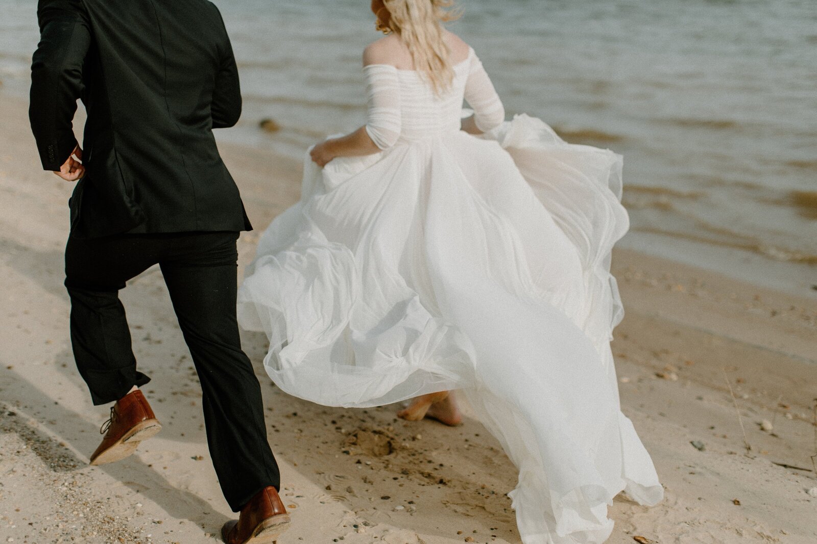 bride and groom running on the beach