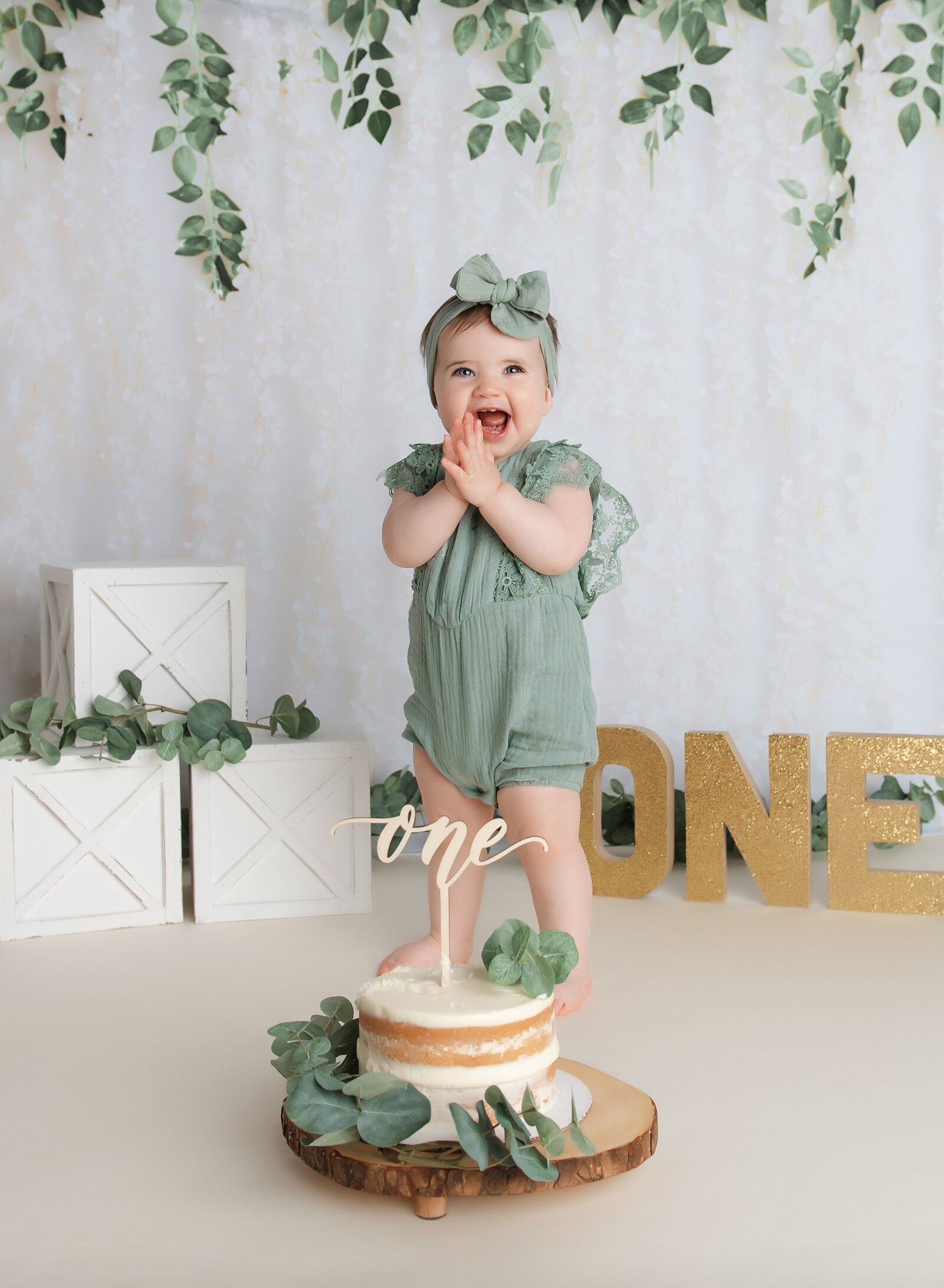 Cake smash photoshoot near me with eucalyptus set up for first birthday pictures.