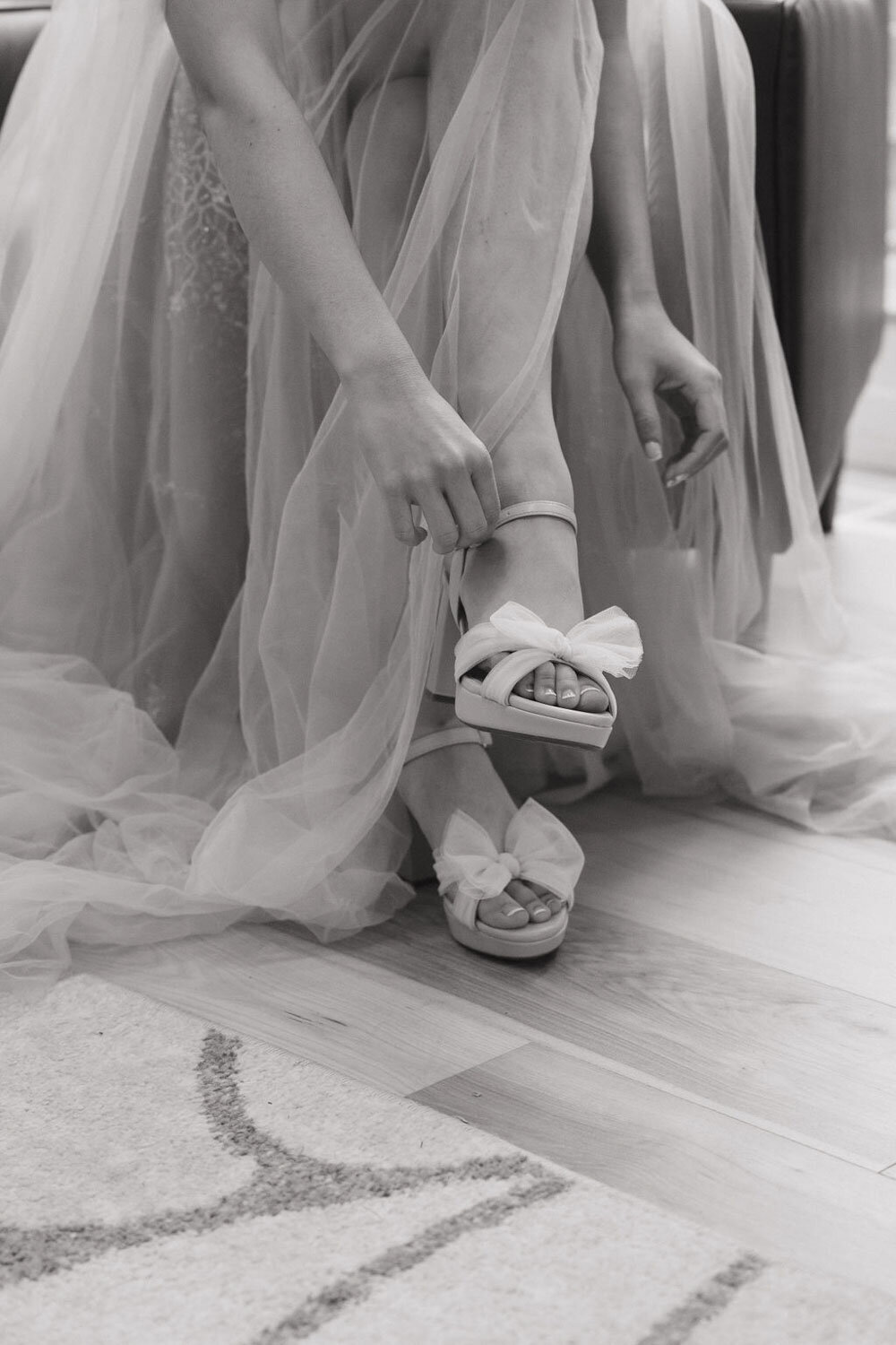 close up of bride fixing her wedding heels