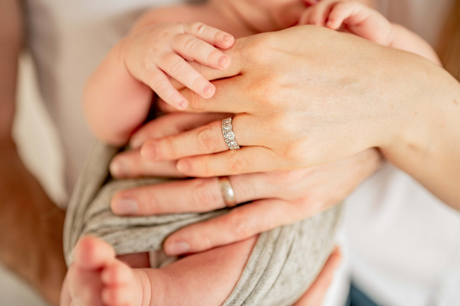 newborn hands with parents