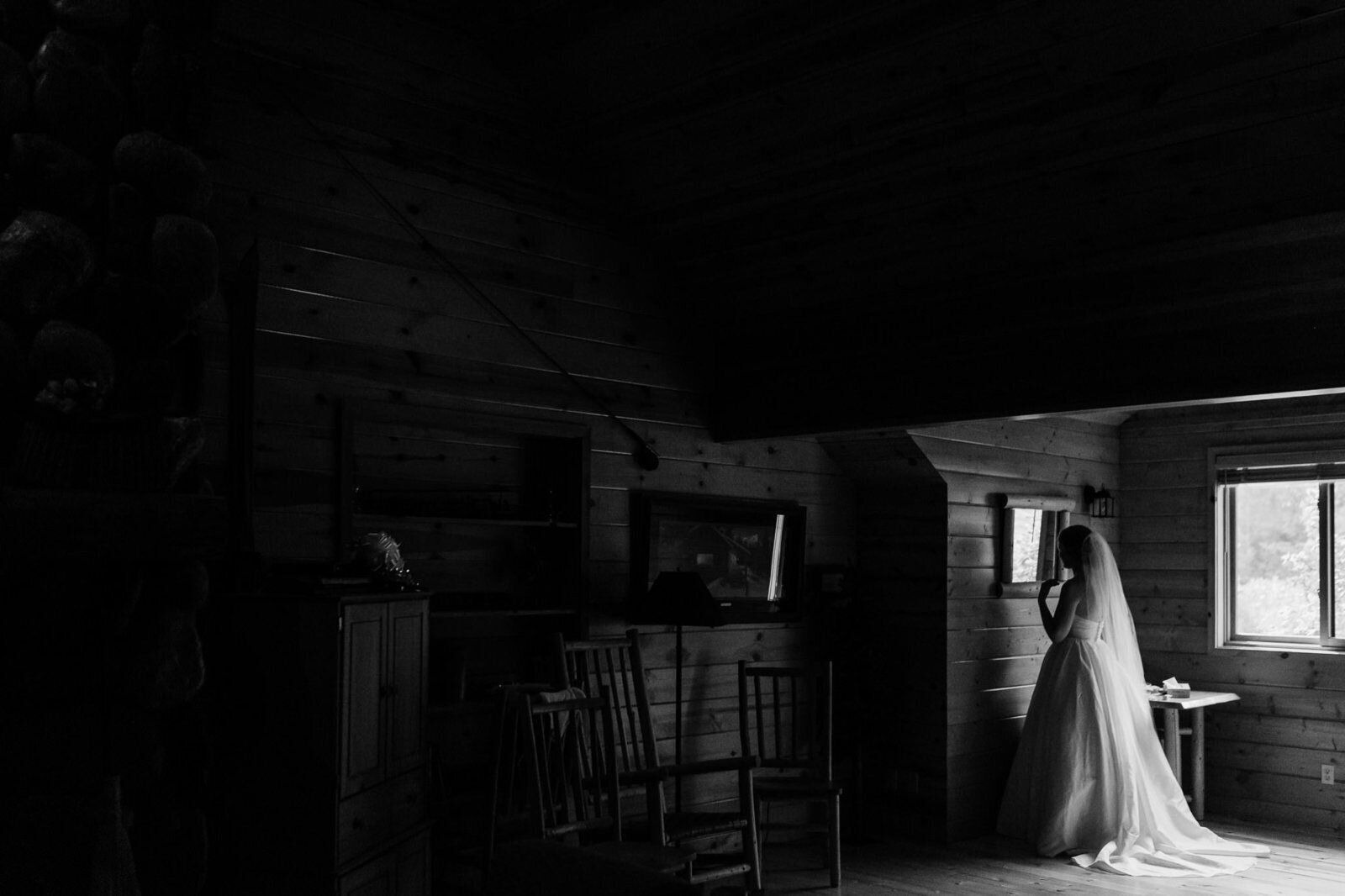 A bride enjoys a quiet moment in a cabin as she gets ready for her mountain elopement in Washington