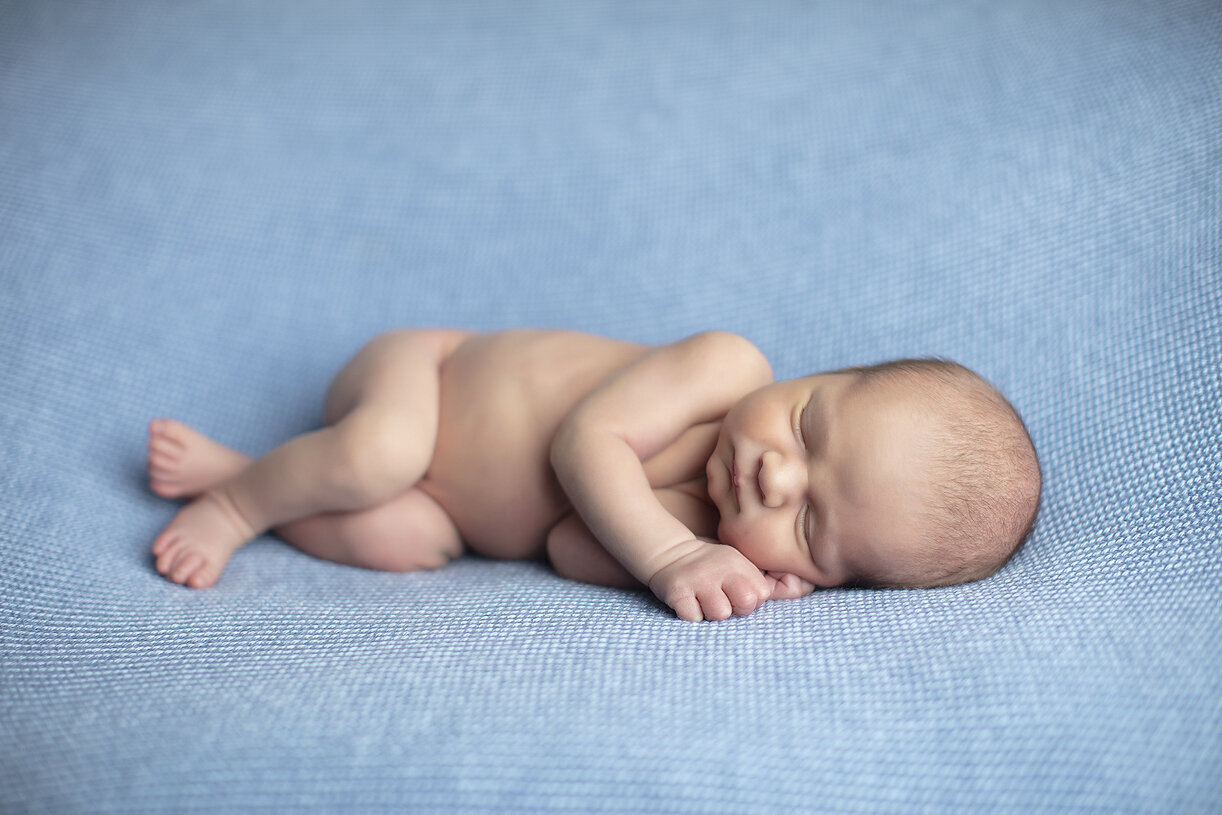 Newborn boy laying on side, a Dallas newborn photographer.