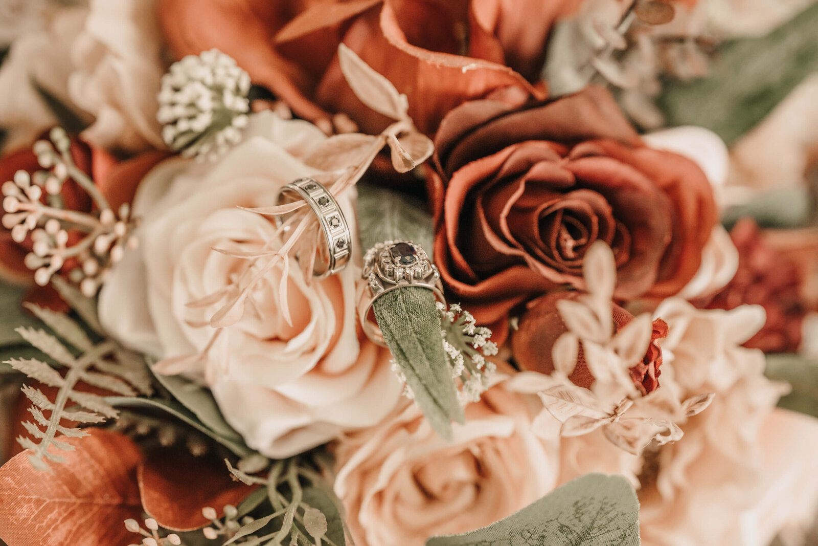 A beautiful wedding ring placed on a colorful bouquet of flowers, representing the union of two hearts.