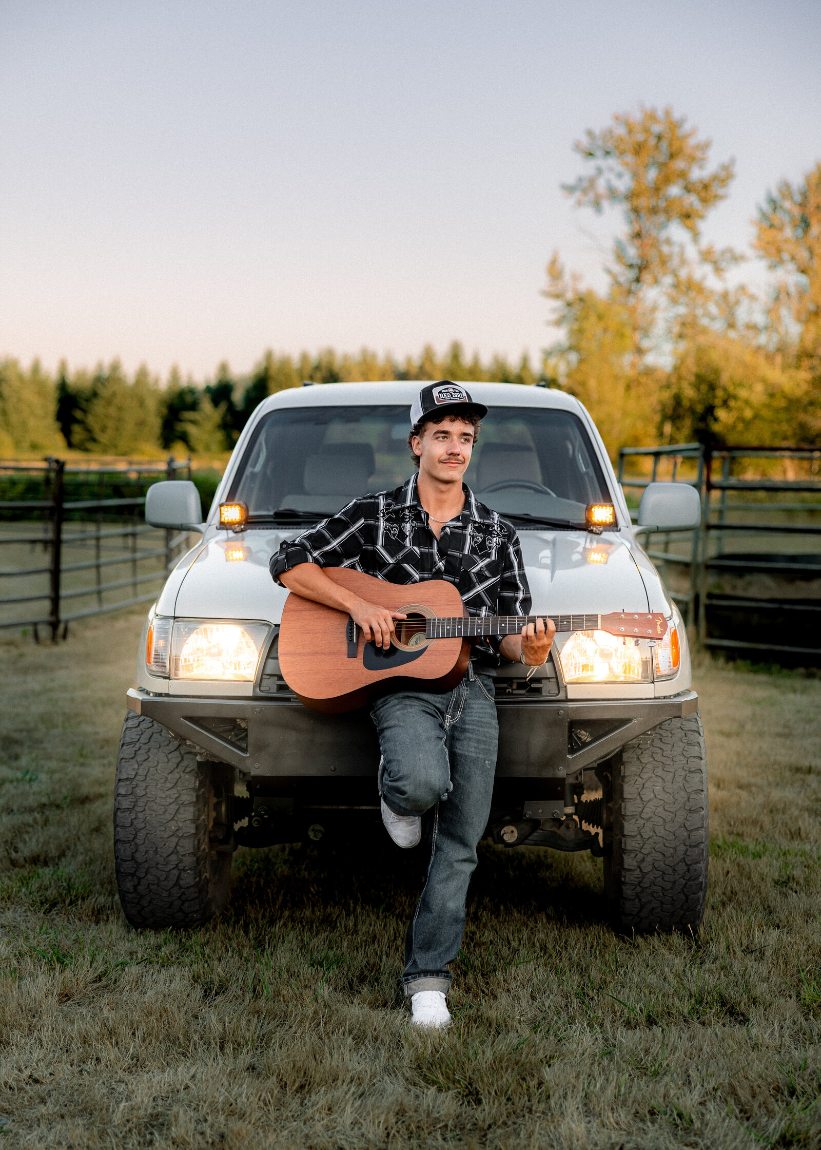 Sam Barlow high school senior taking senior portraits at Milo Mciver Park with his truck and guitar.